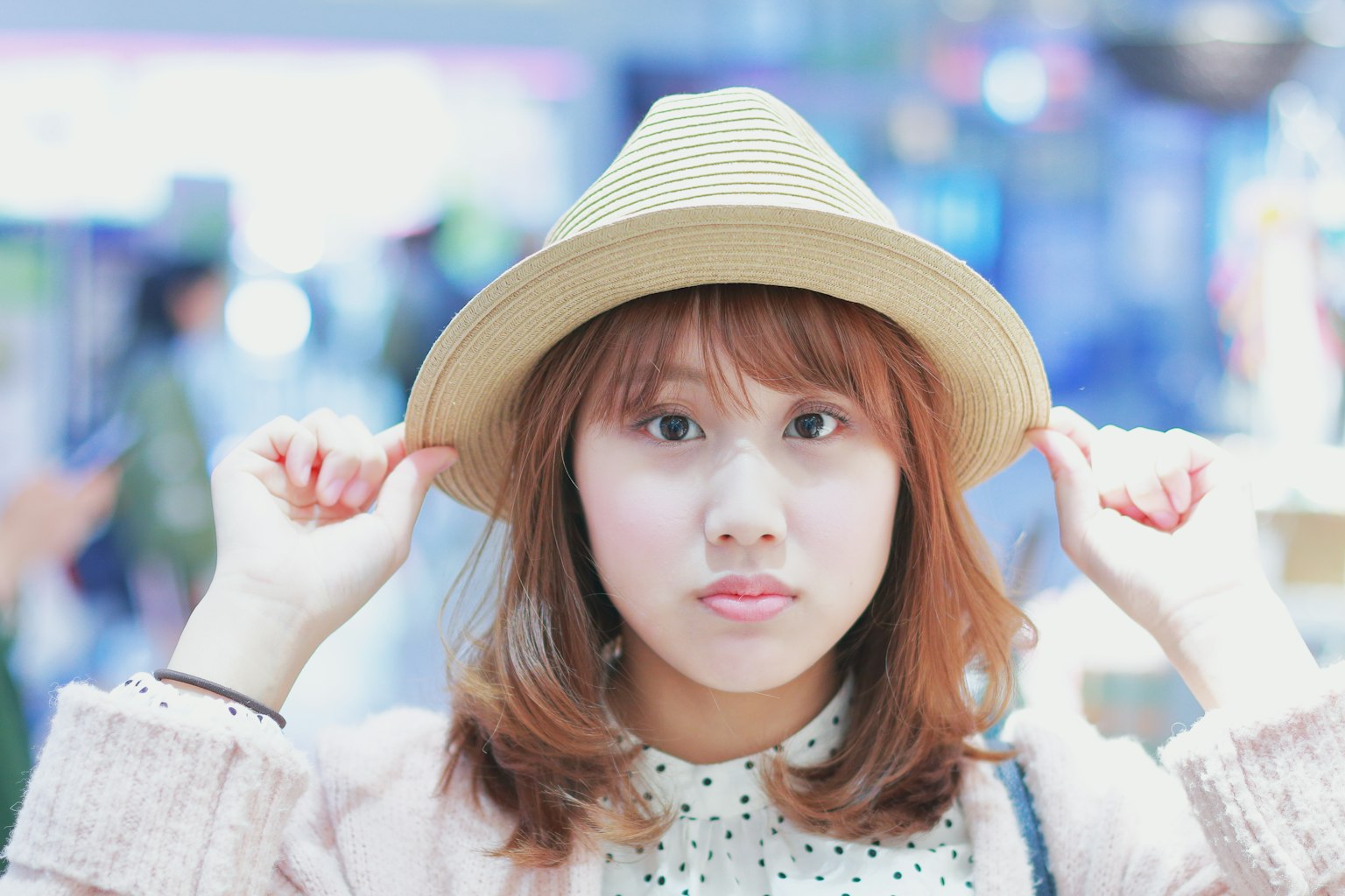 Portrait of a young woman holding a hat with a blurred background