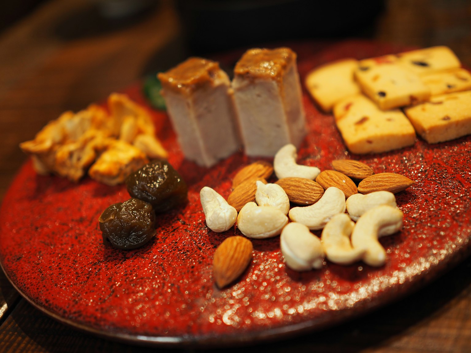 An assortment of sweets and nuts on a red plate