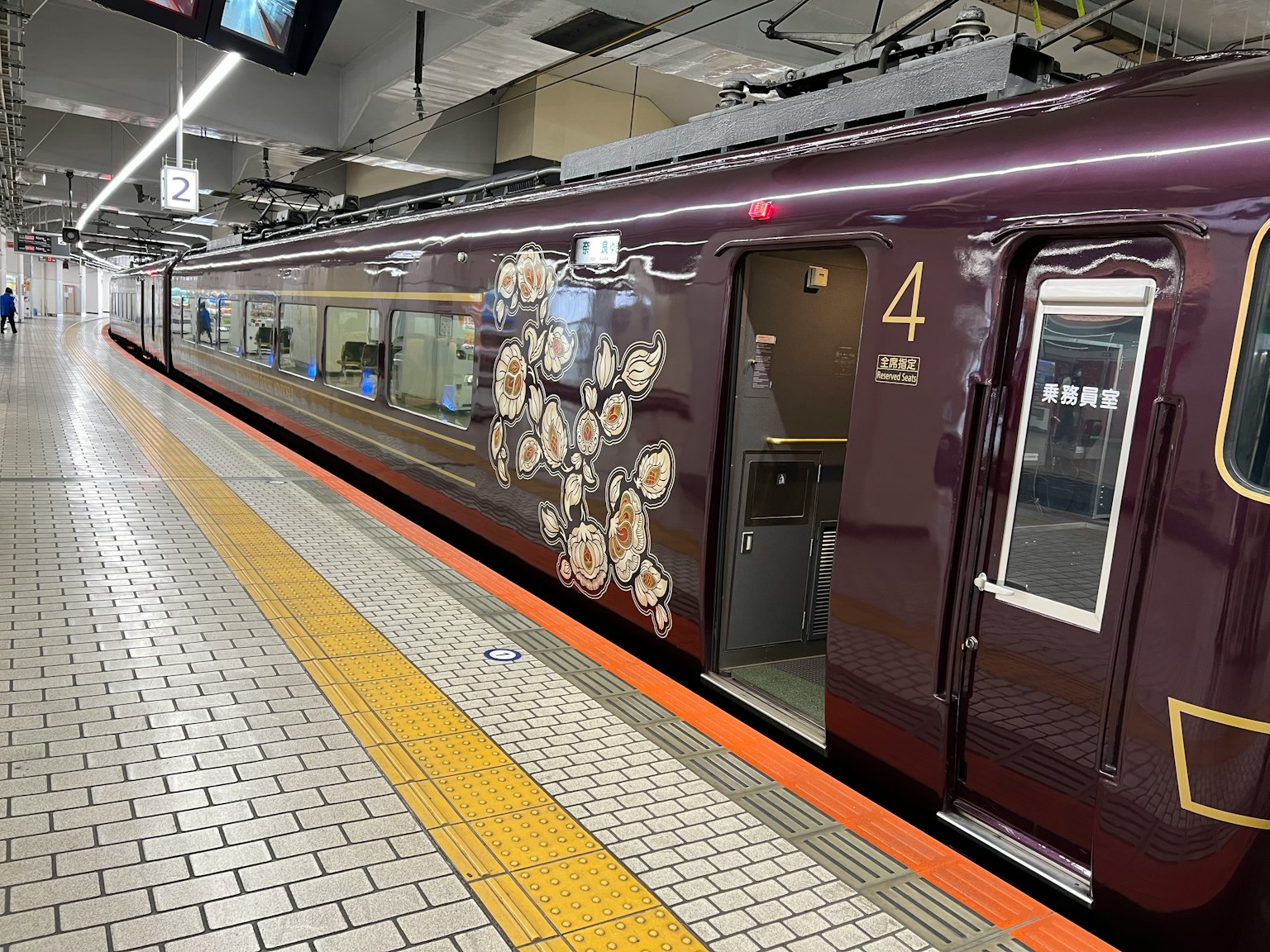 紫色列車停靠在車站月台上，帶有裝飾元素和編號4
