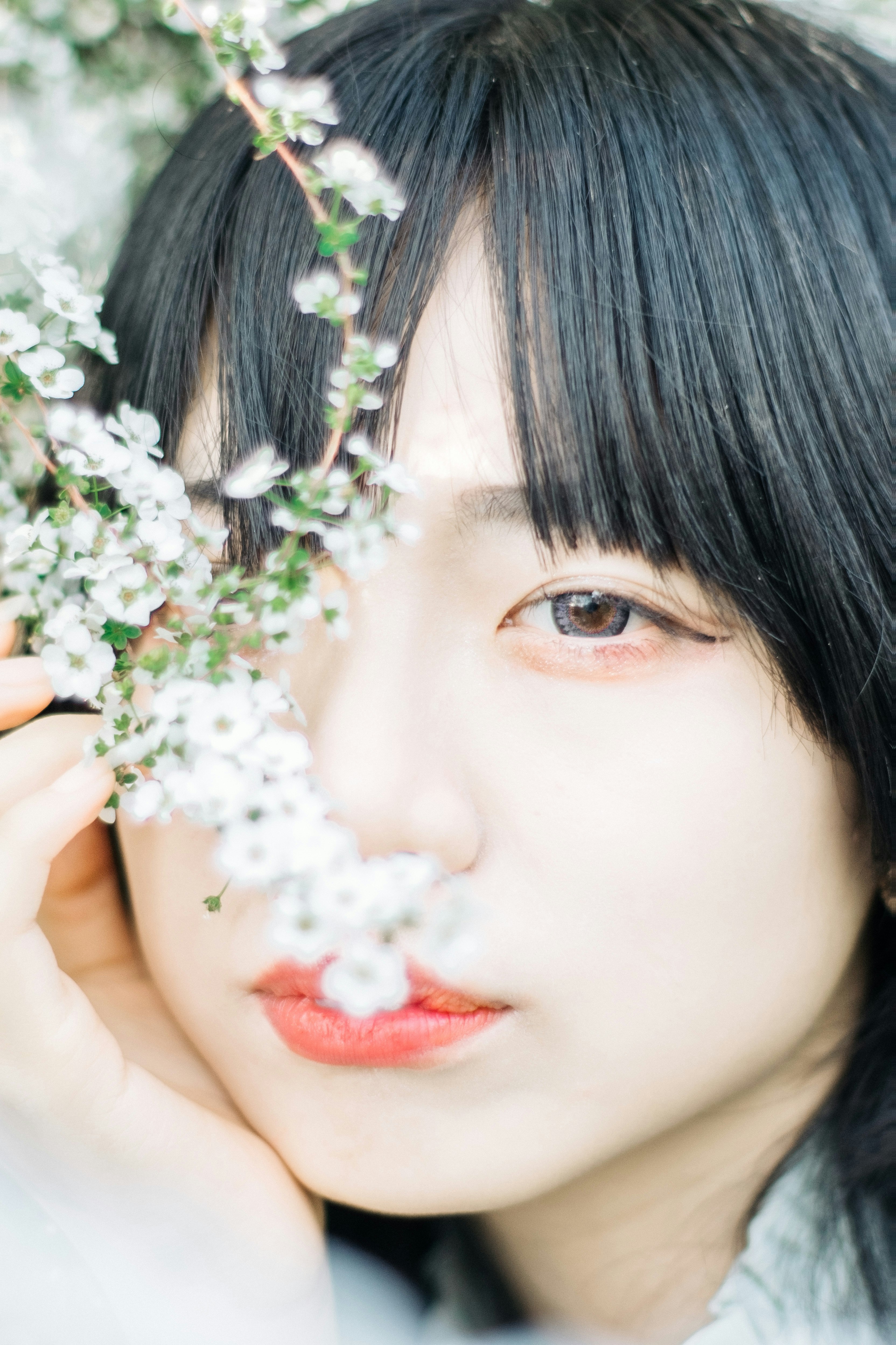 花冠のような白い花に寄り添う女性のやわらかな横顔