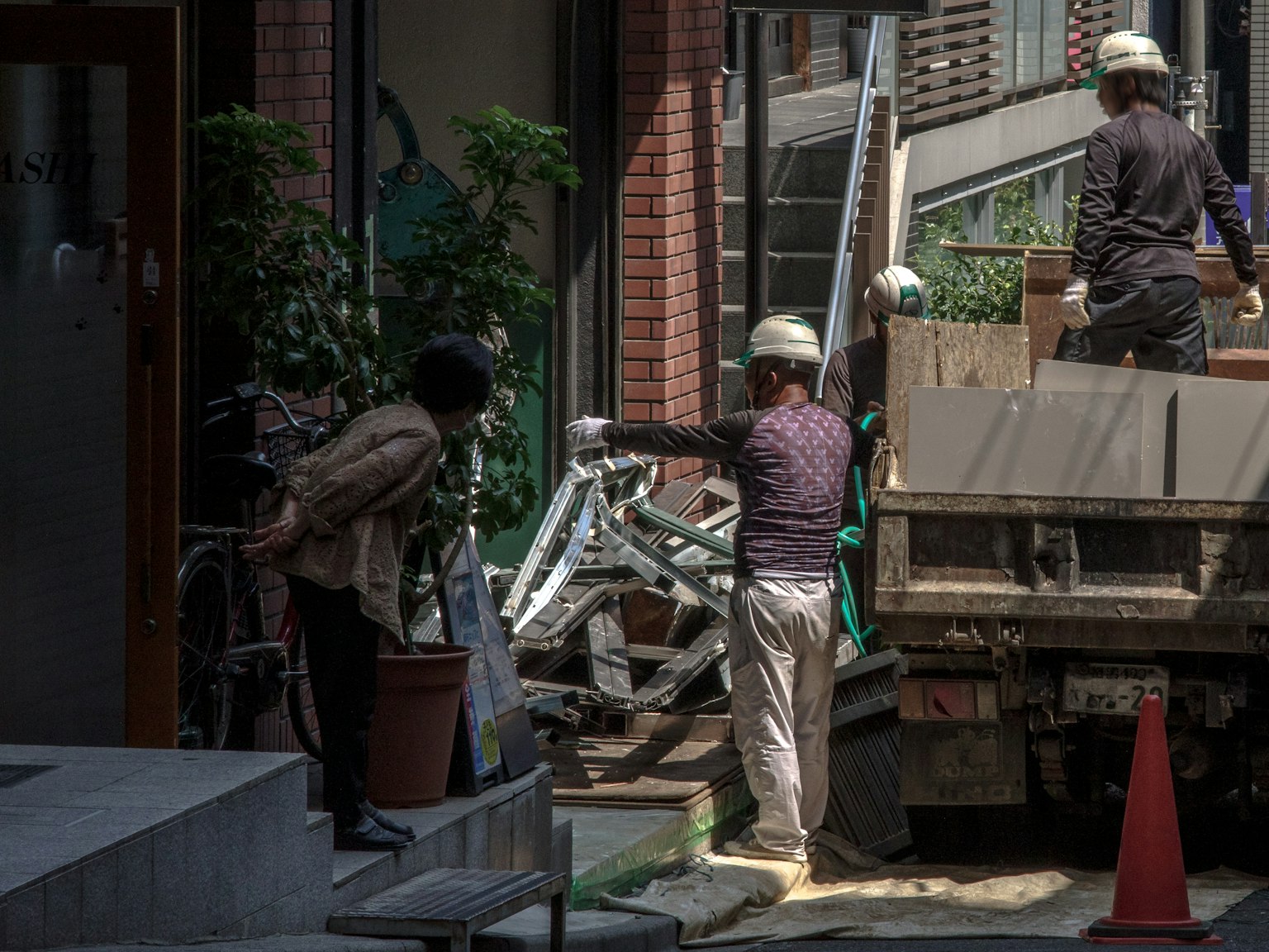 Trabajadores descargando materiales de un camión en un entorno urbano