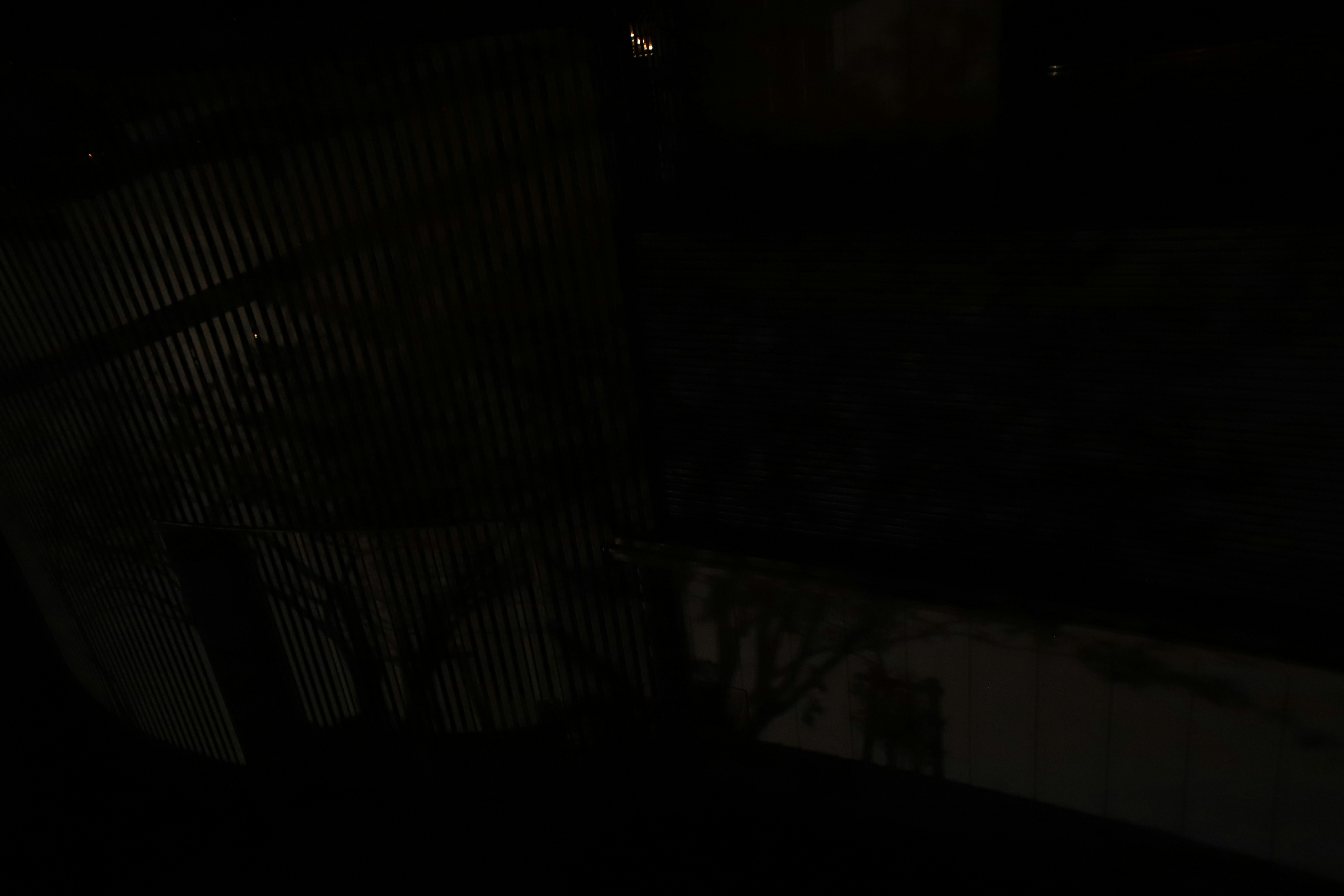 dark indoor space with light spilling across a wall and floor