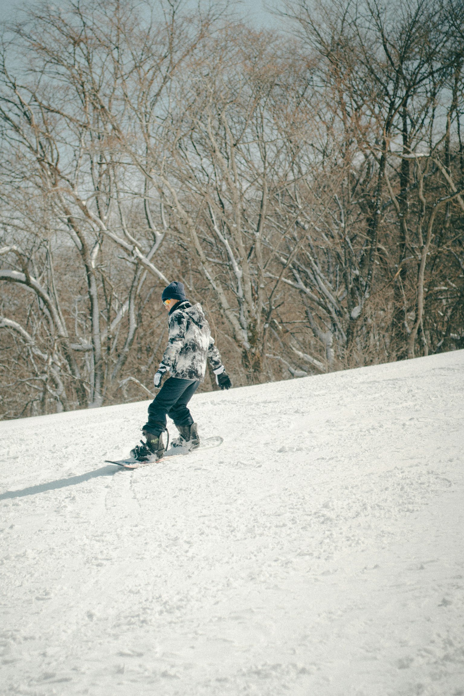 Un hombre snowboarder deslizándose por una pendiente nevada