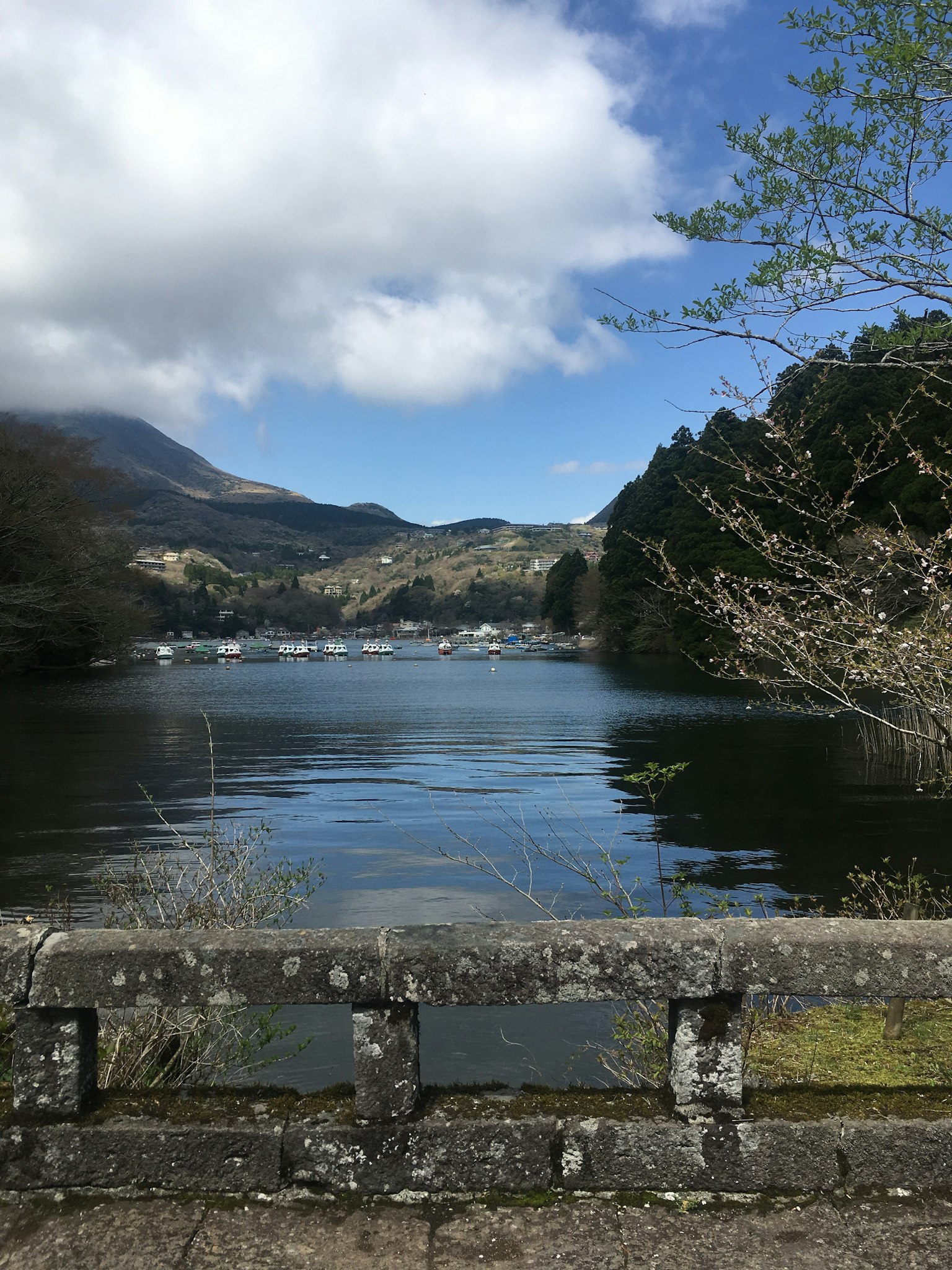 Calm lake view with mountains and a blue sky with clouds