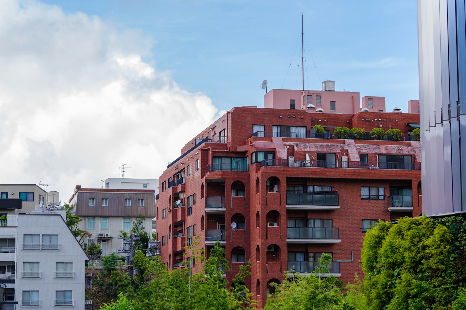 Escena urbana con un edificio de ladrillo rojo y vegetación