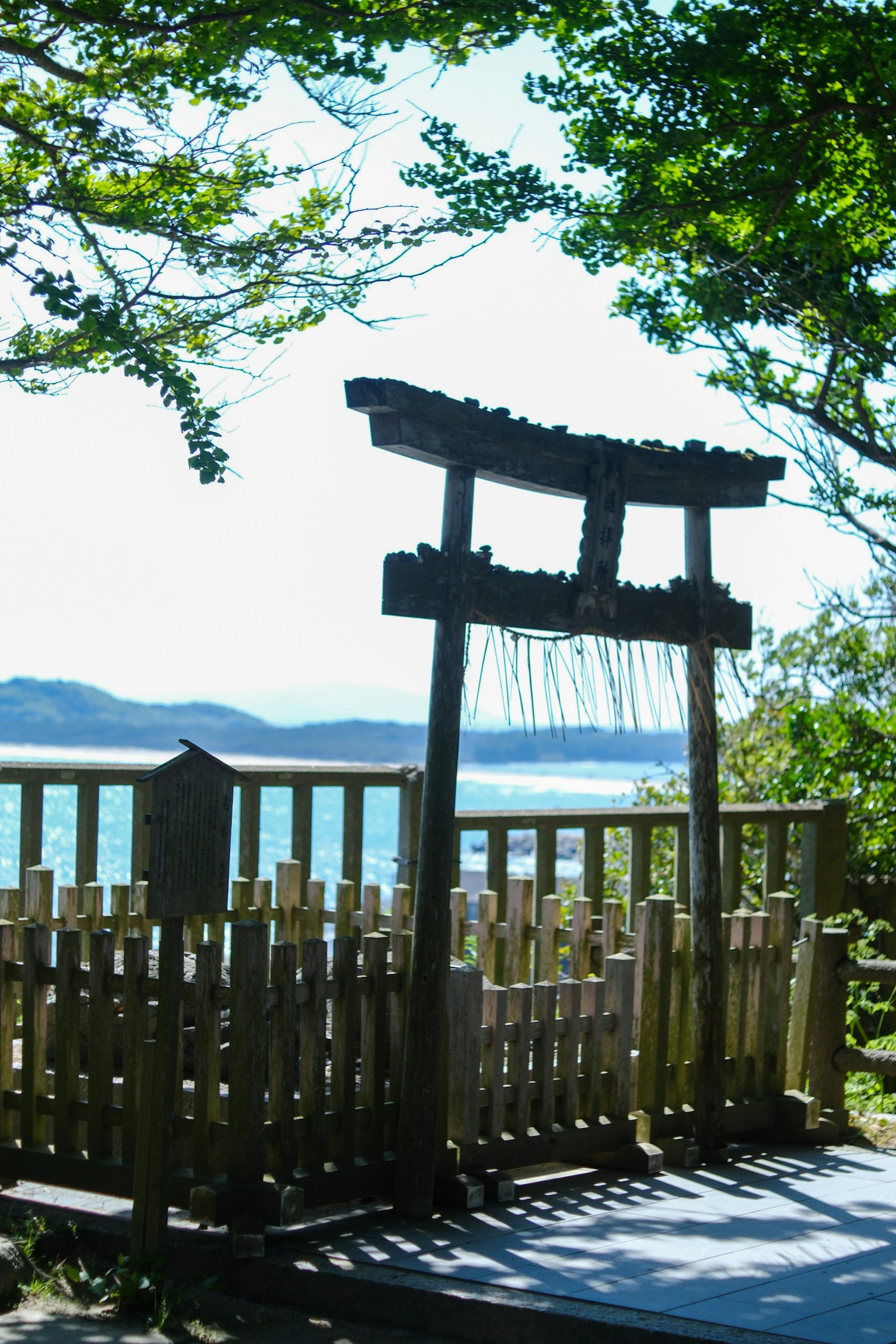 Gerbang torii kayu dikelilingi oleh pepohonan hijau dan pemandangan indah