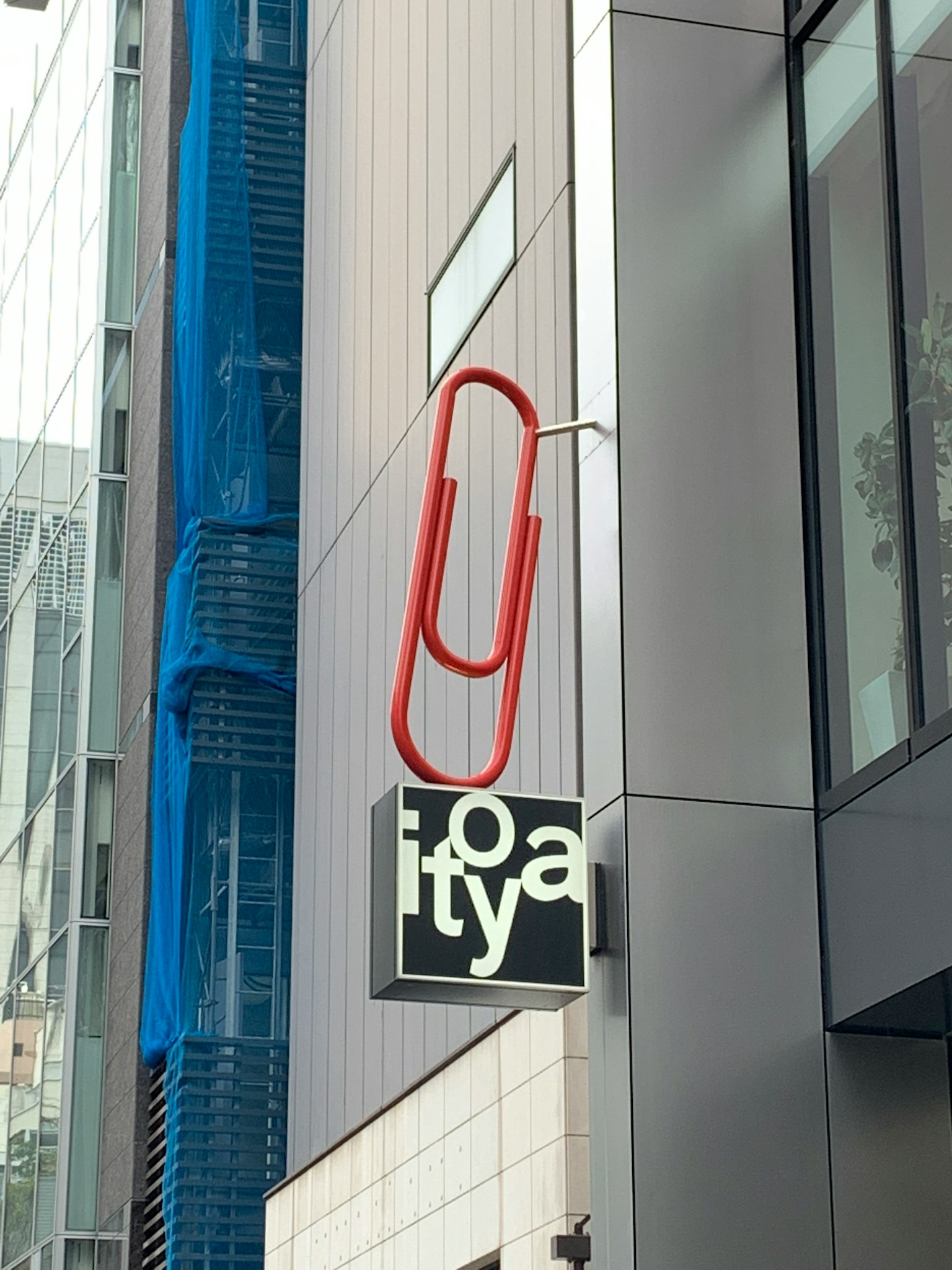 建筑外观，带有红色回形针形状的招牌