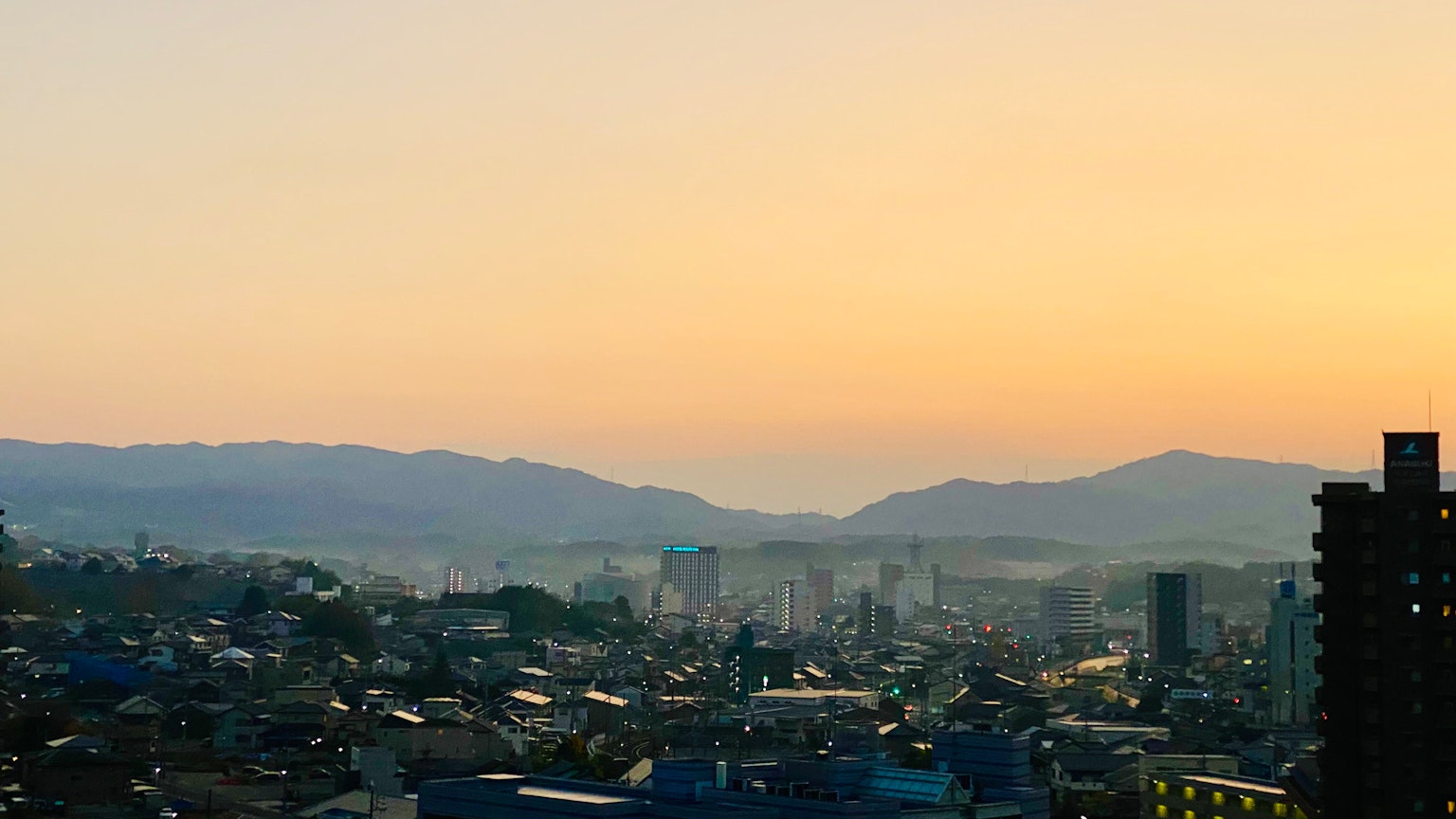 Vue panoramique d'une ville au crépuscule avec des montagnes et des bâtiments