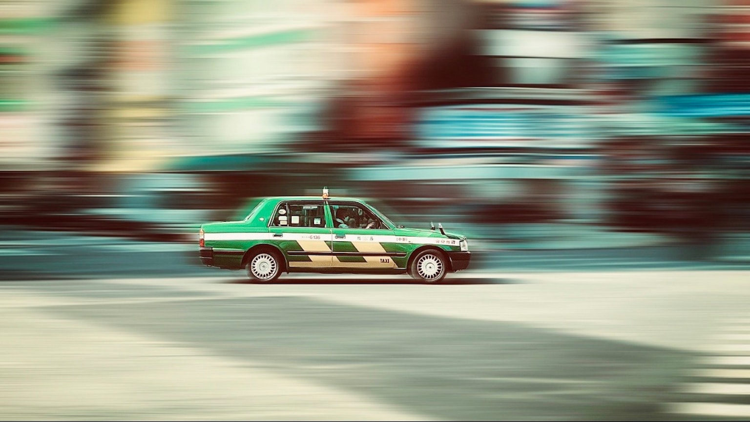 動いているタクシーが背景のぼやけた都市風景を通過するシーン