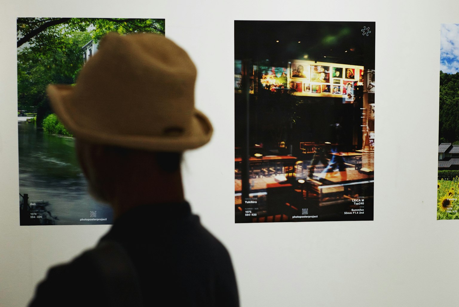戴帽子的人在展览中观察艺术作品