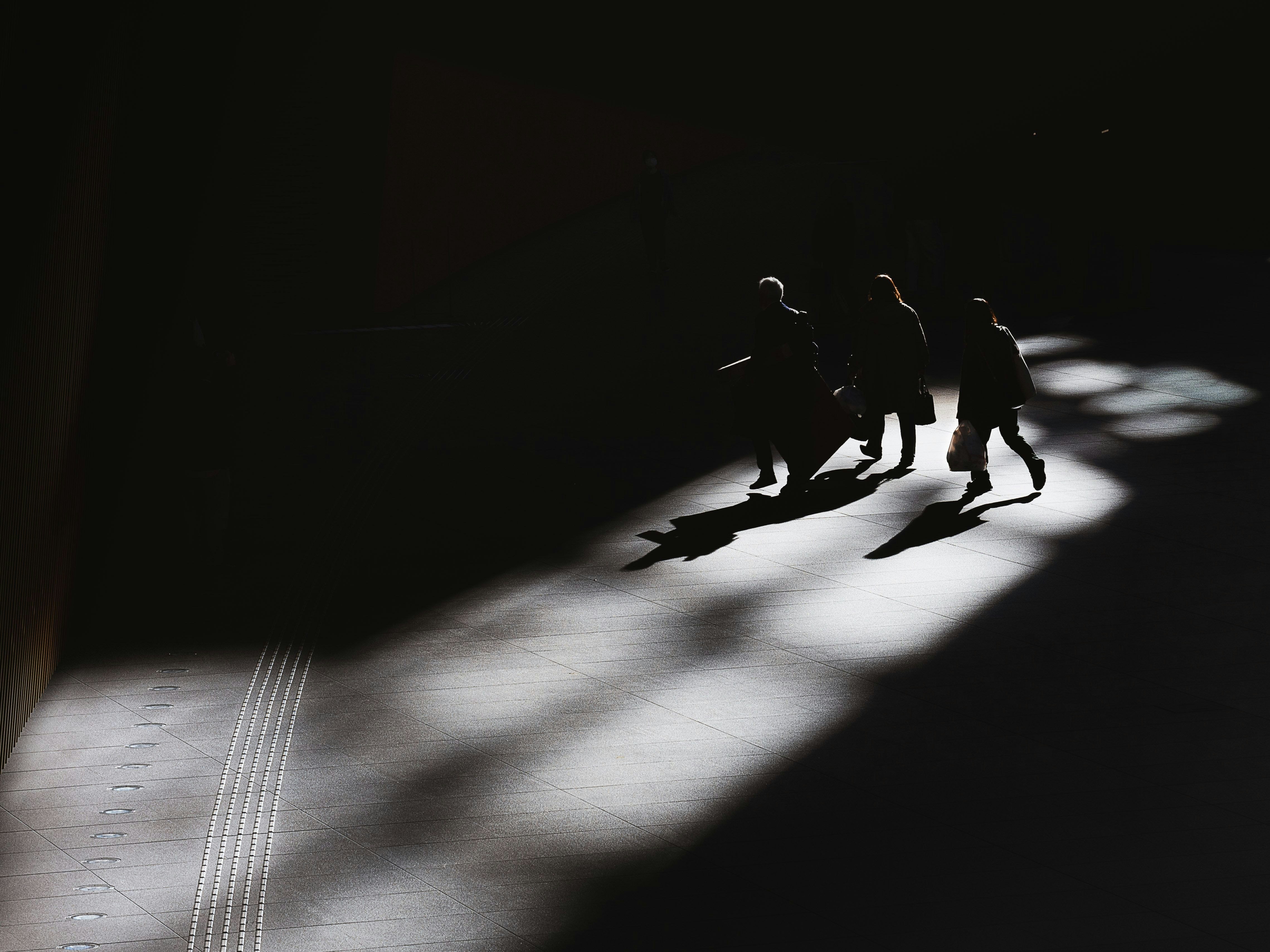 Silhouettes de personnes marchant dans un couloir sombre