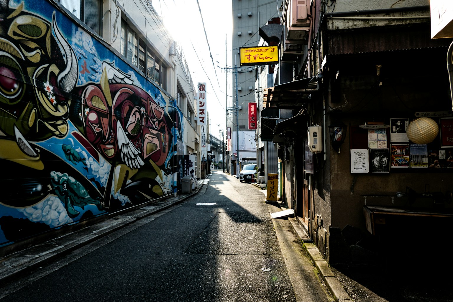 Narrow alley featuring colorful graffiti and old buildings