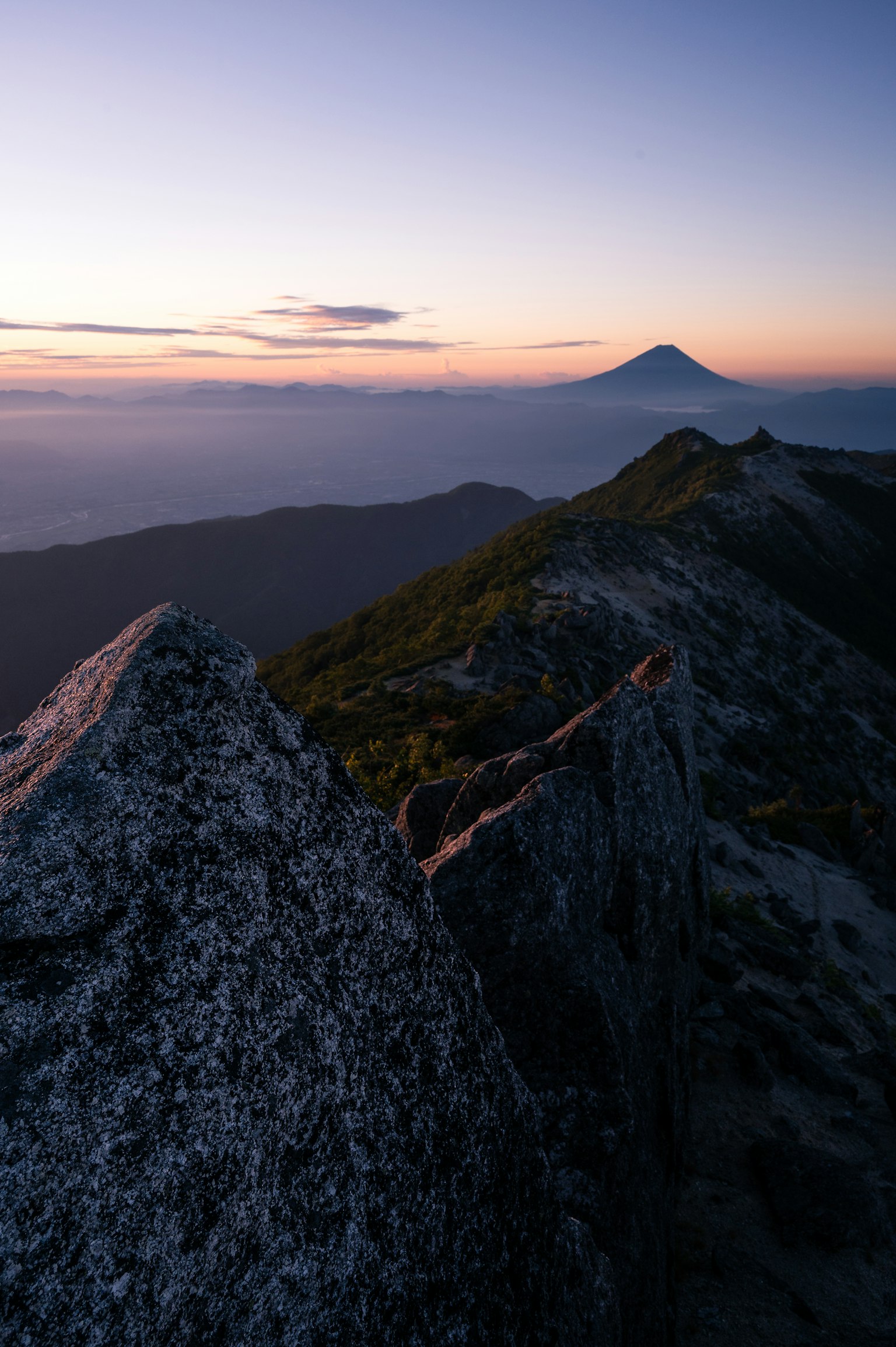 Berglandschaft mit Sonnenuntergang große Felsen und entfernter Vulkan