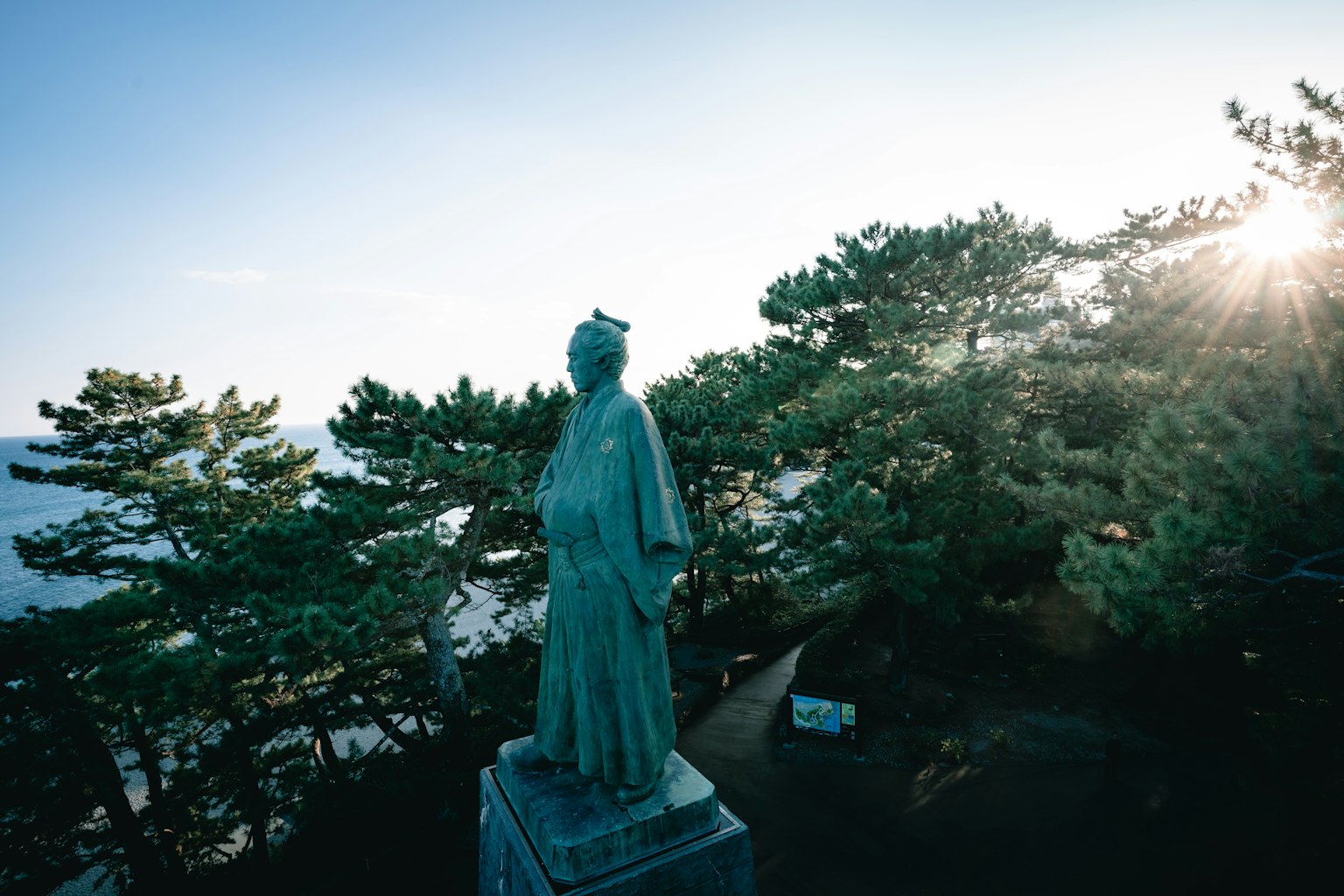 俯瞰海洋的銅像與松樹