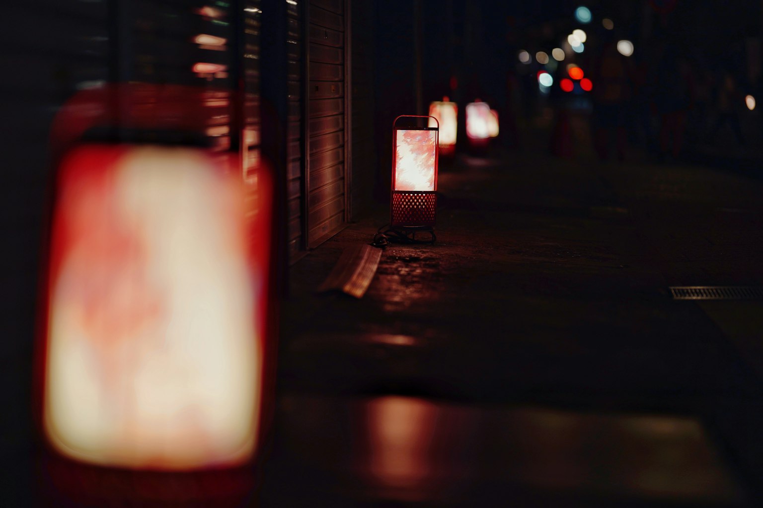 Fila de faroles rojos iluminando una calle nocturna