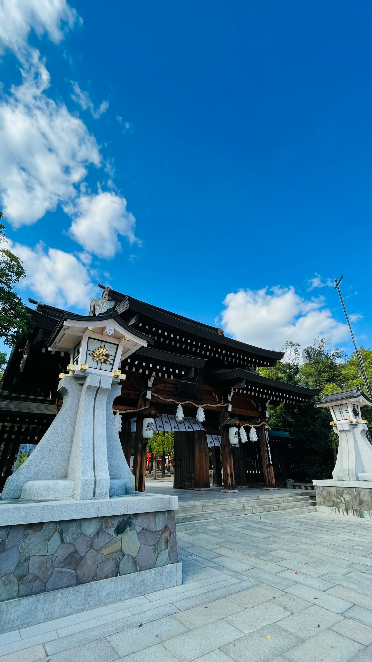 藍天下的傳統神社門和石燈籠