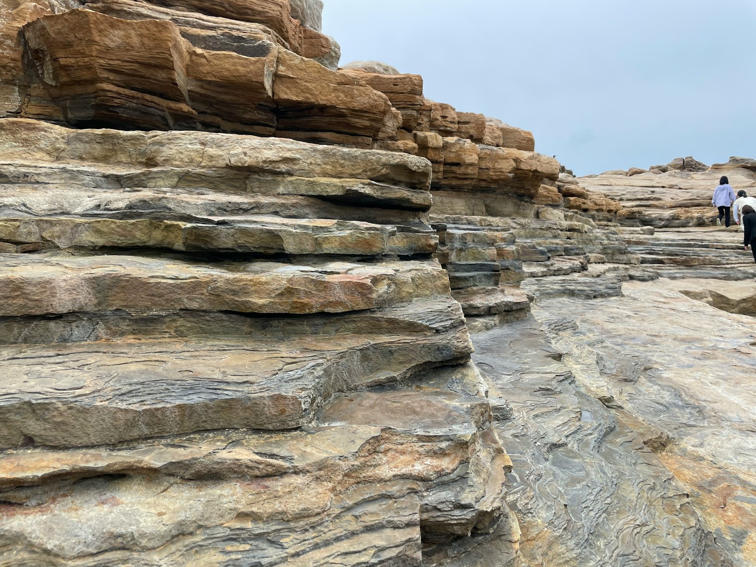Layered rock formations with people walking