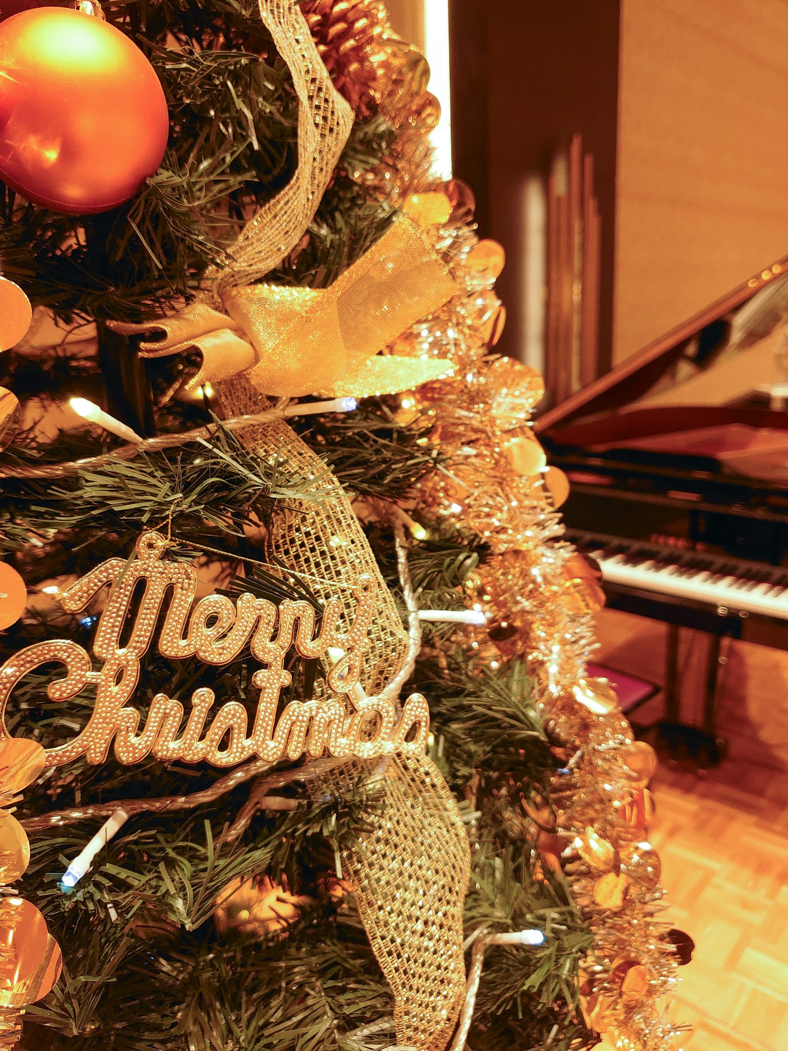 Cây thông Noel trang trí và đàn piano trong một căn phòng ấm cúng
