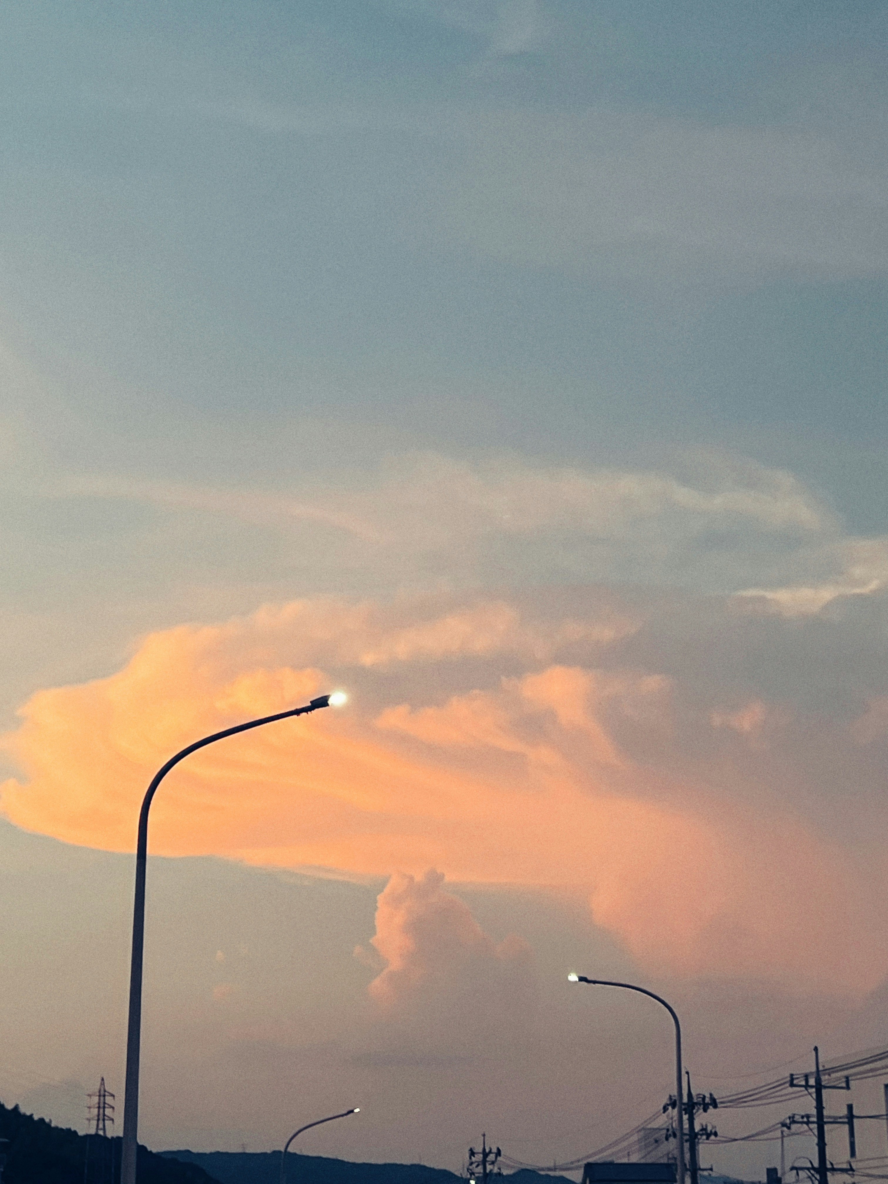 夕焼け空に煙の上がる工業地帯の遠景