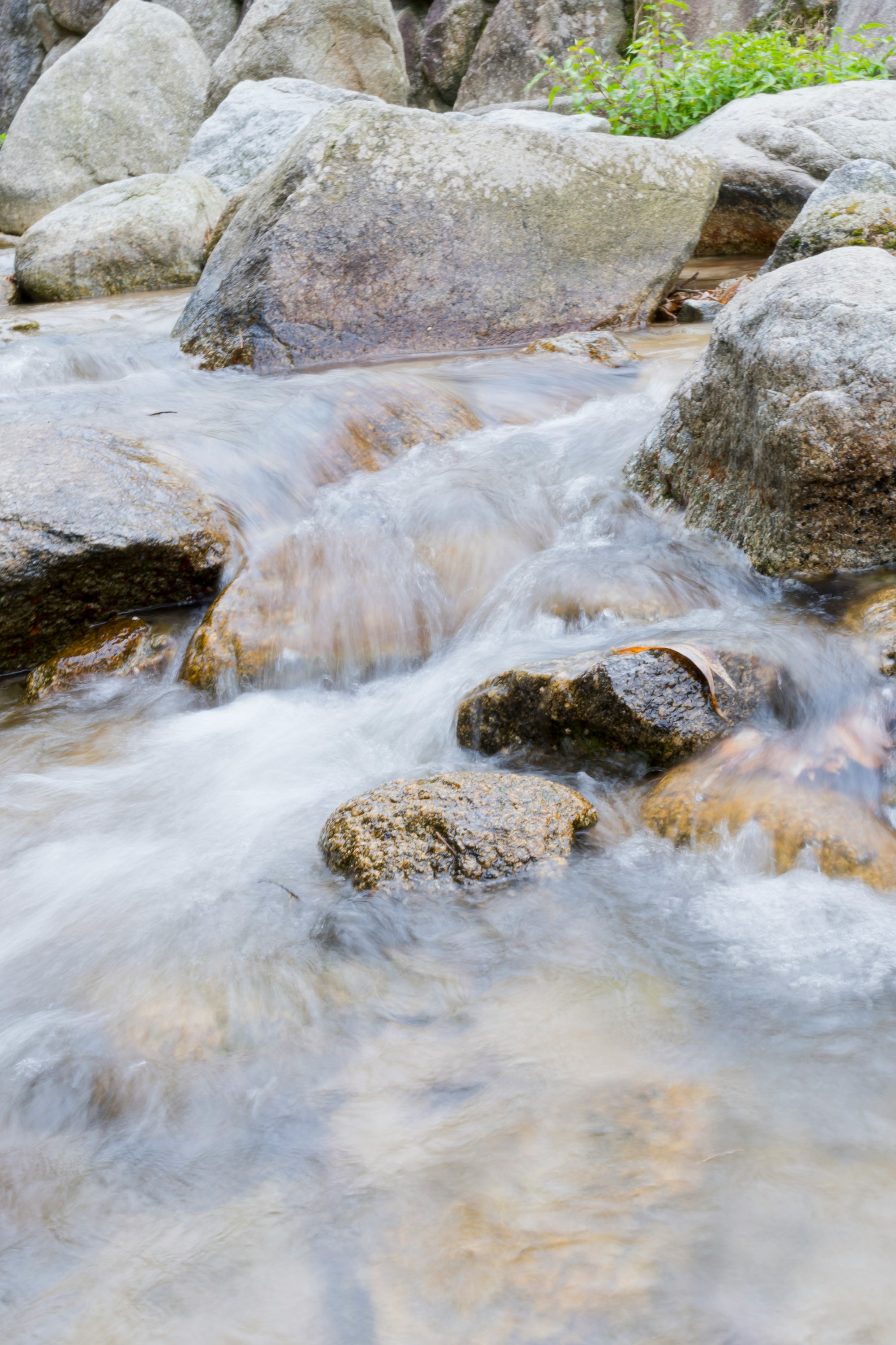 small stream water flowing between rocks
