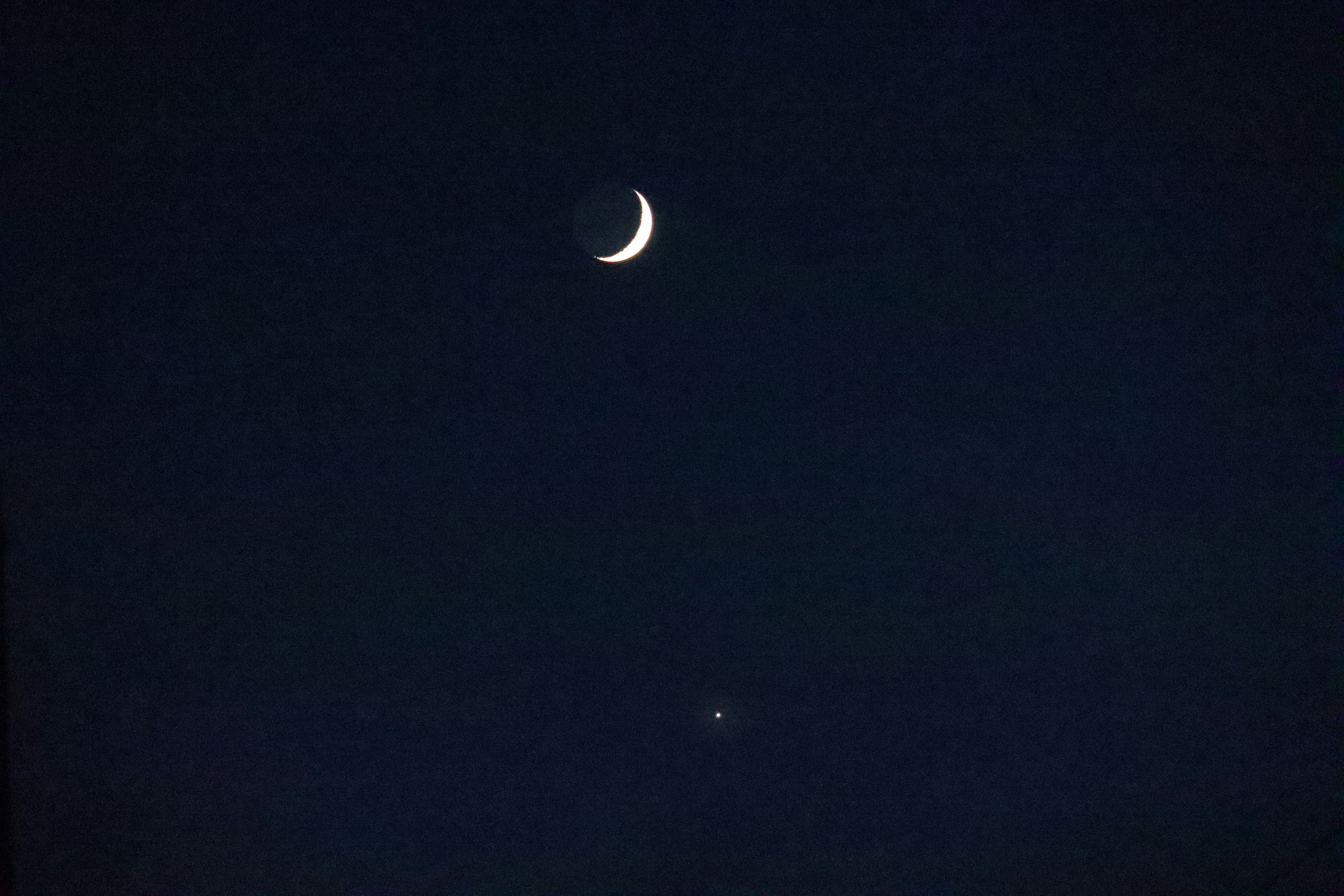 夜空に浮かぶ月と小さな星の点