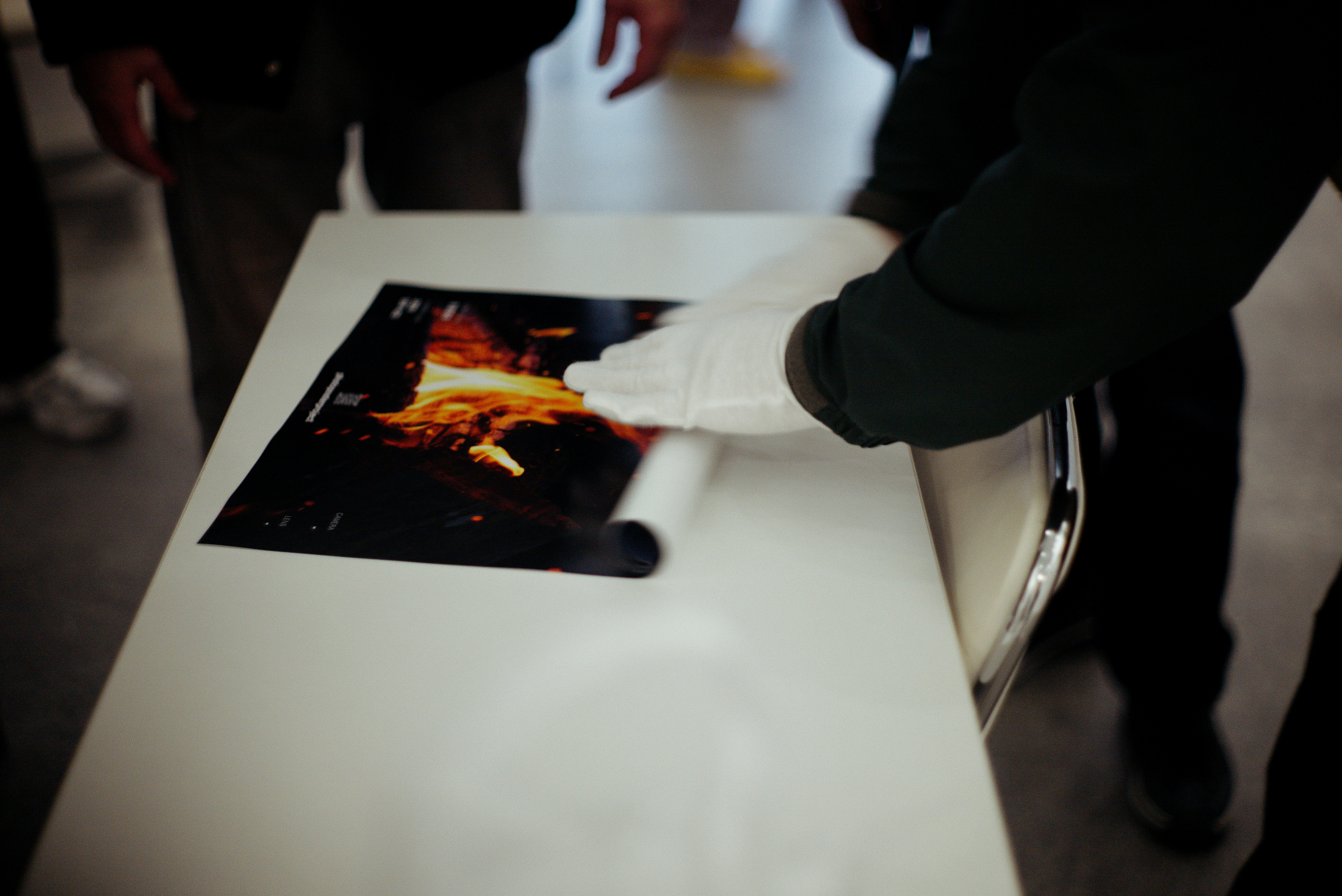 京都の展示会場で写真ポスターを手に取る人の手元