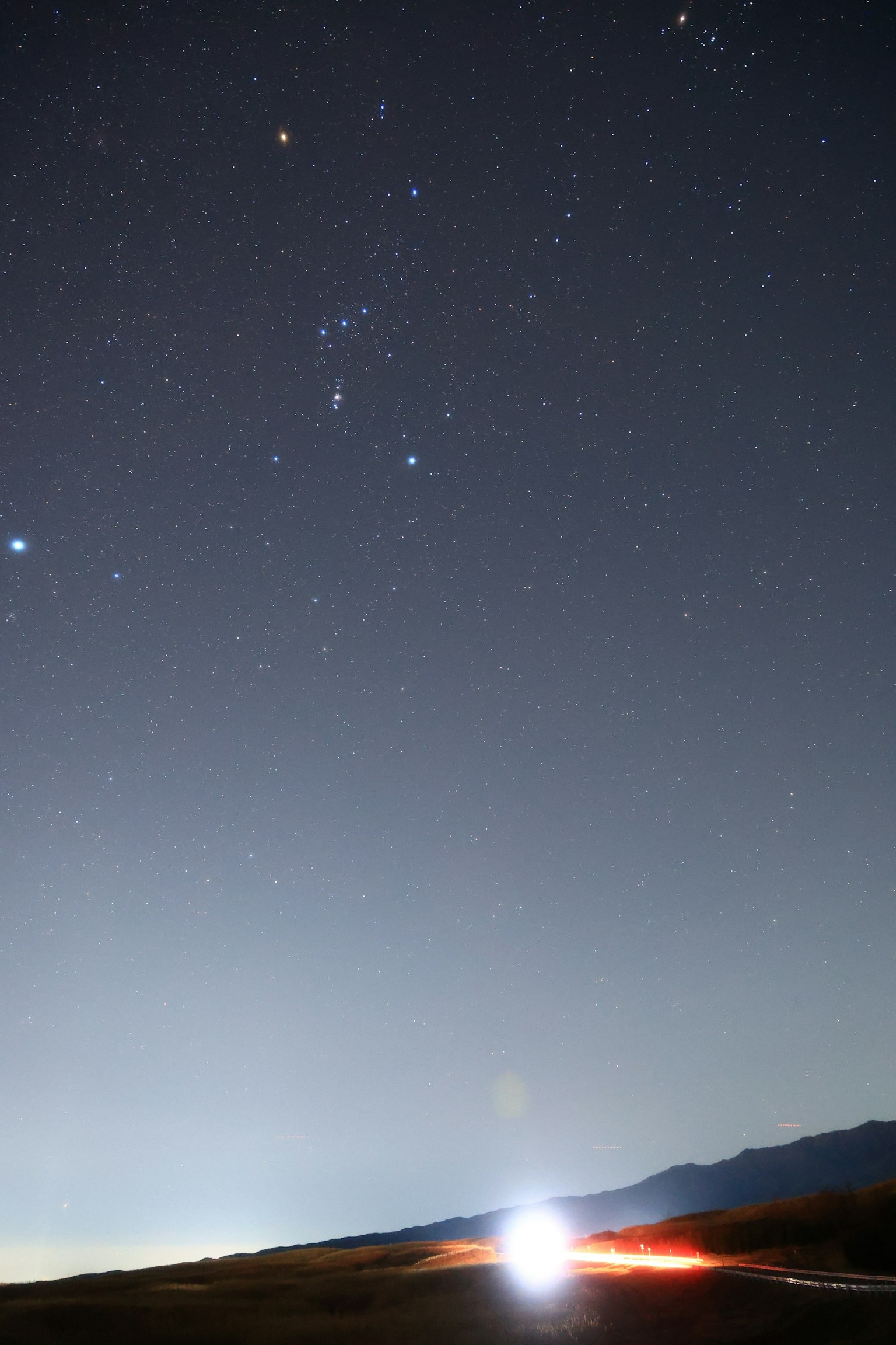 Night landscape featuring a starry sky and distant mountains