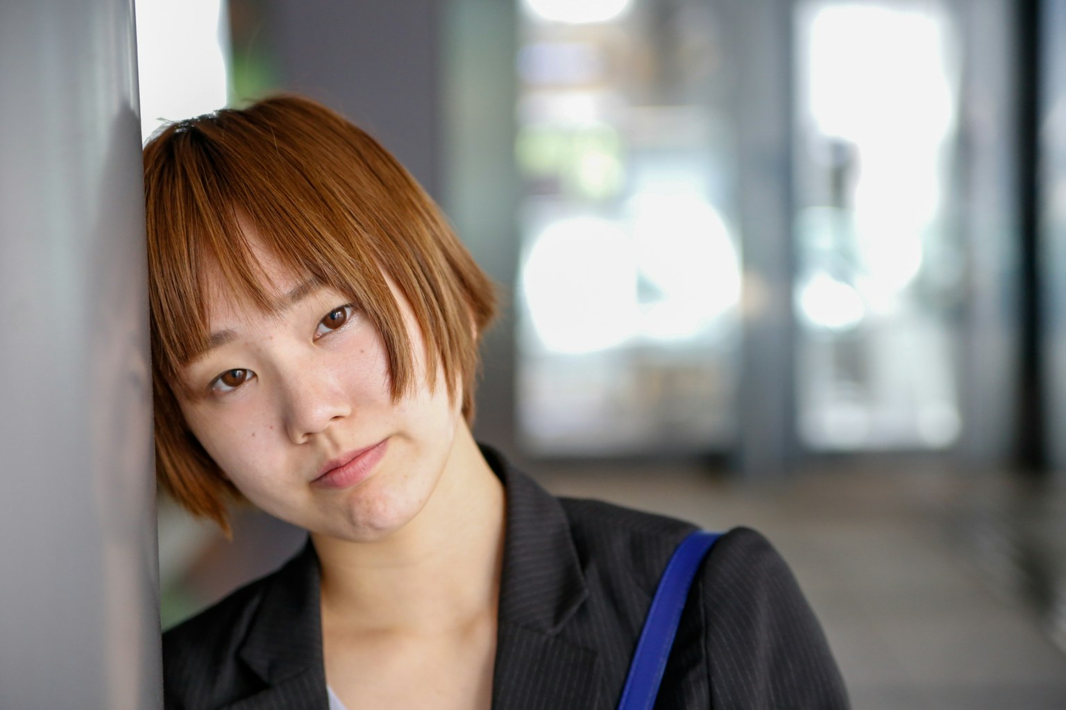 หญิงสาวพิงกำแพงด้วยสีหน้าคิด
