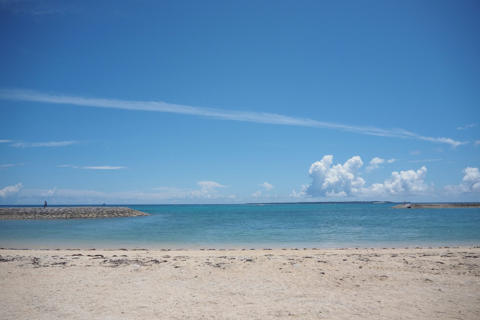 Scenic view of a blue sky and calm sea with a sandy beach