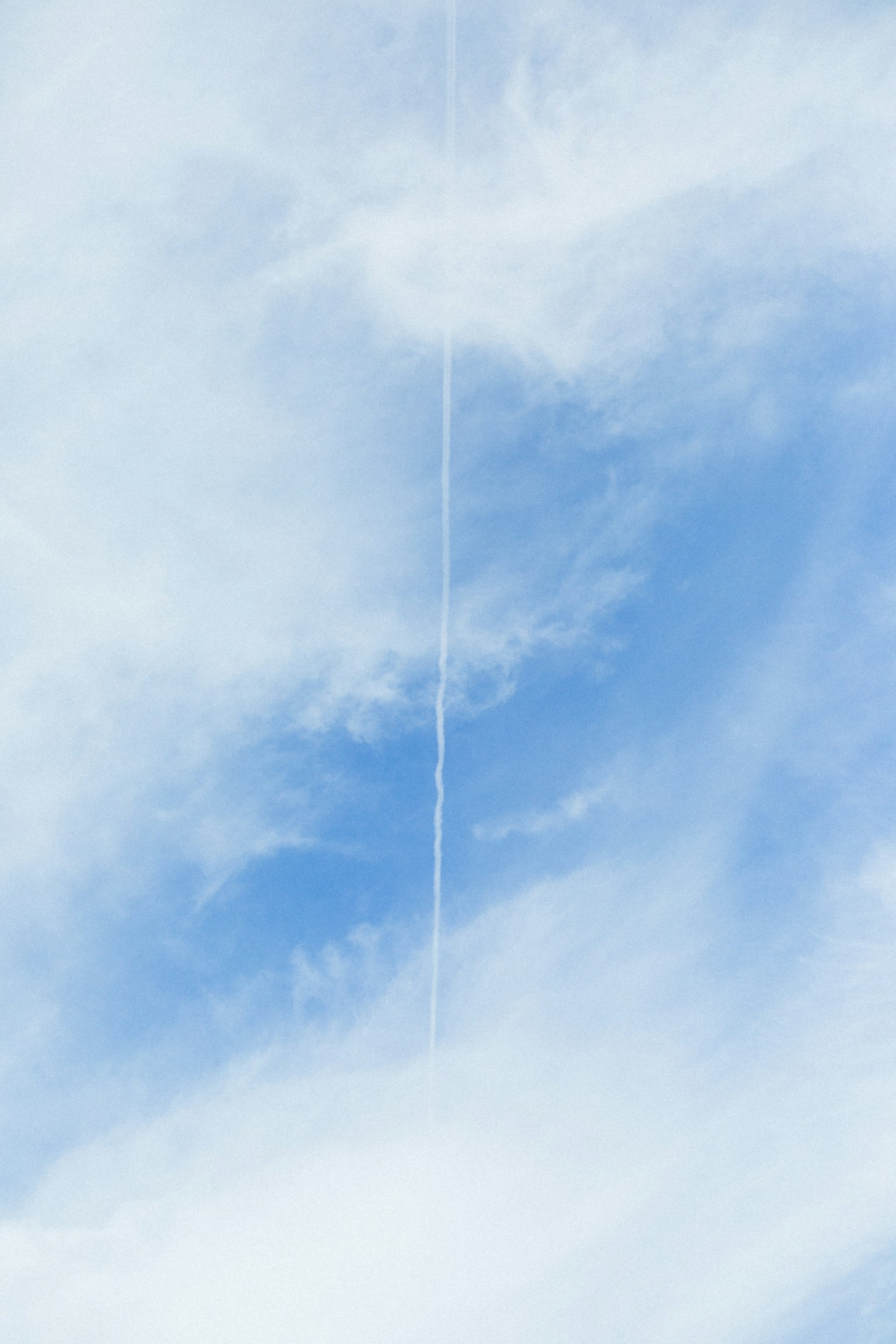 Traînée blanche dans un ciel bleu avec des nuages