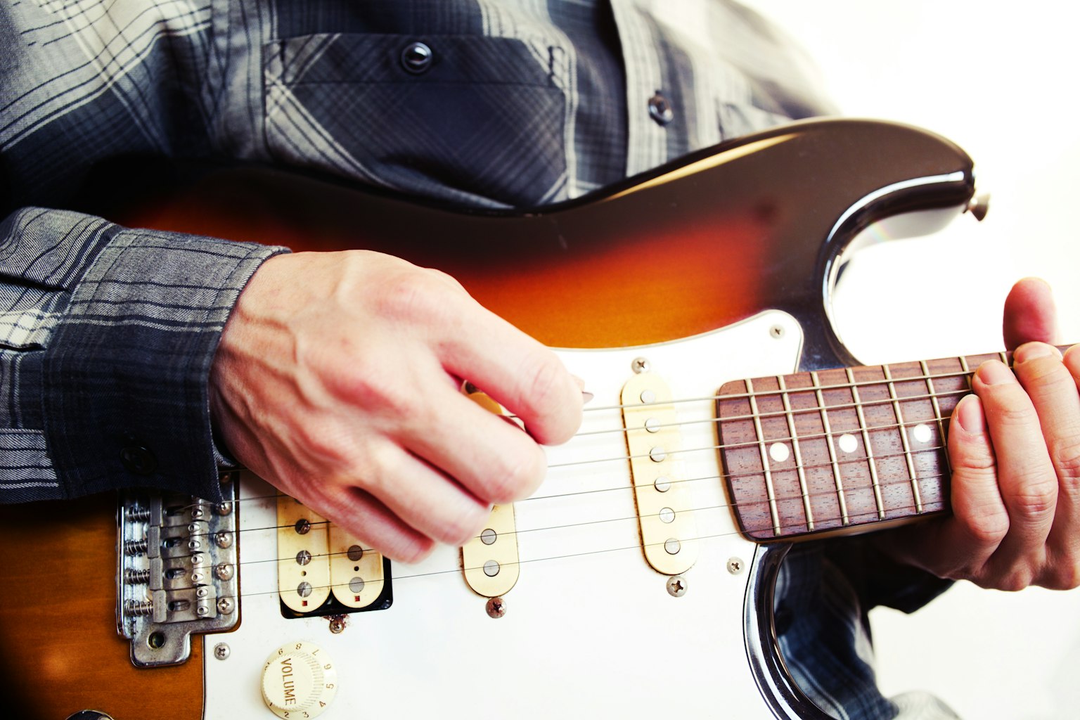 Close-up of hands playing an electric guitar
