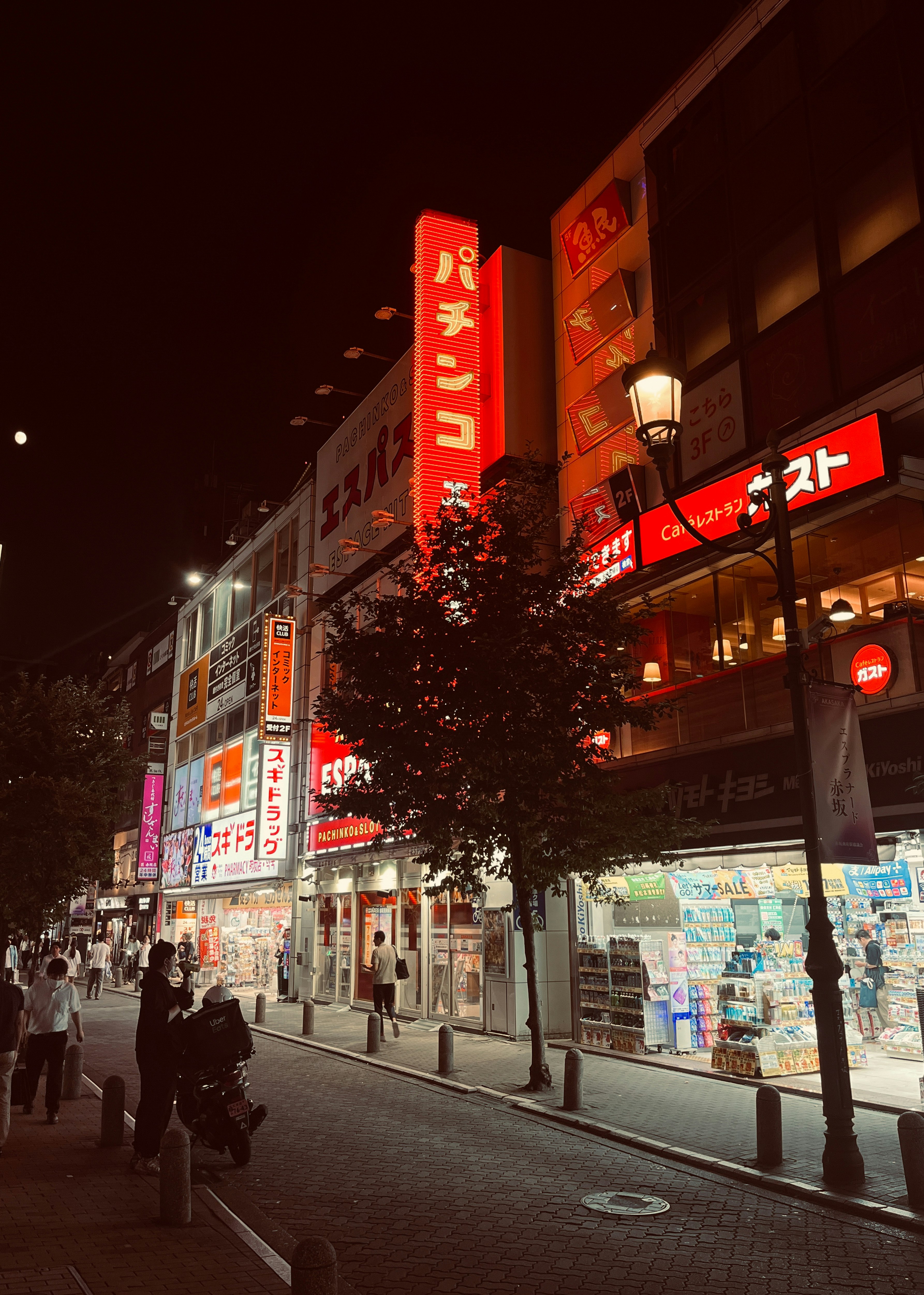 夜の繁華街でネオン看板が並ぶ通りの風景