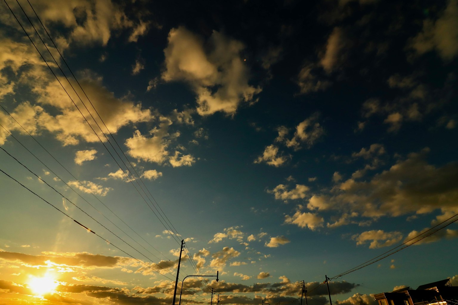 Lebhafter Himmel mit verstreuten Wolken und einem Sonnenuntergang am Horizont