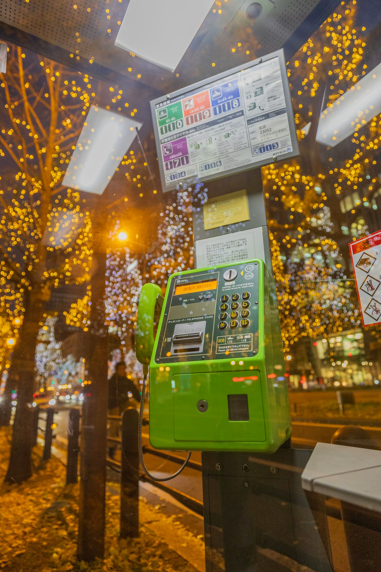 ตู้โทรศัพท์ริมถนนที่ถูกไฟประดับในตอนกลางคืน