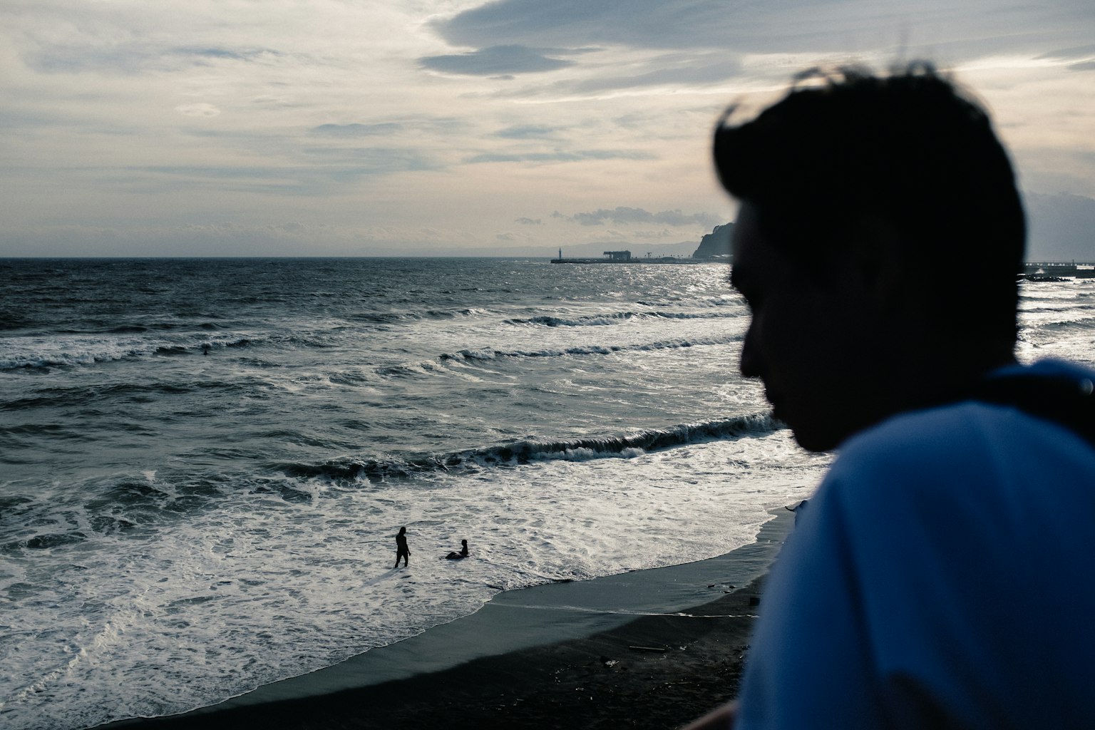 Silueta de una persona mirando las olas en la playa