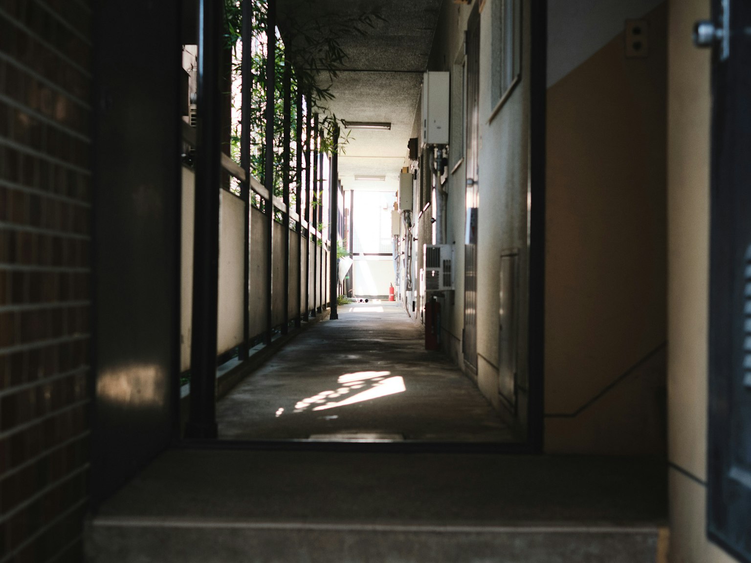 Photo d'un couloir faiblement éclairé avec de la lumière entrant par le fond