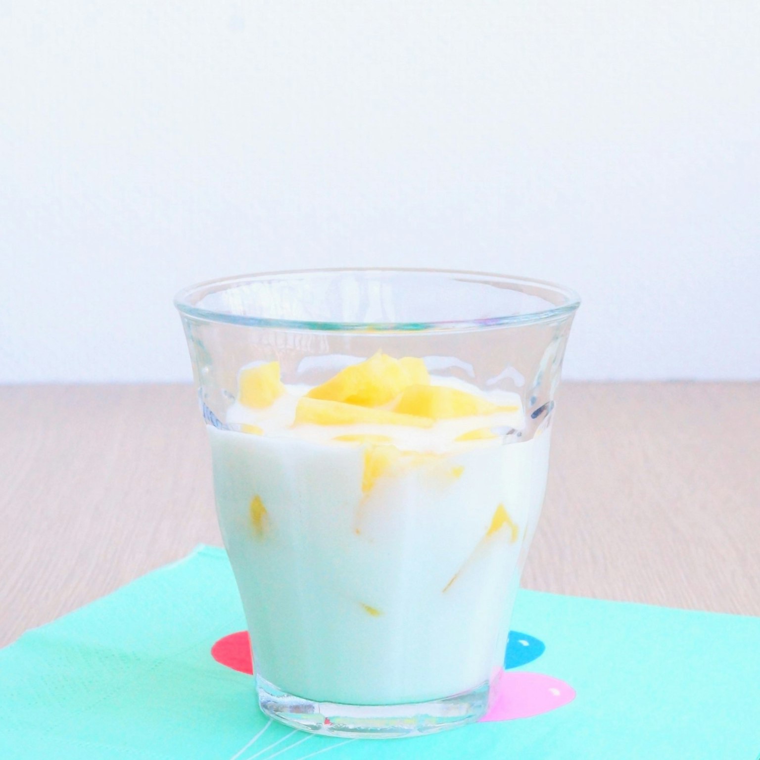 A glass of mango yogurt dessert with visible mango pieces
