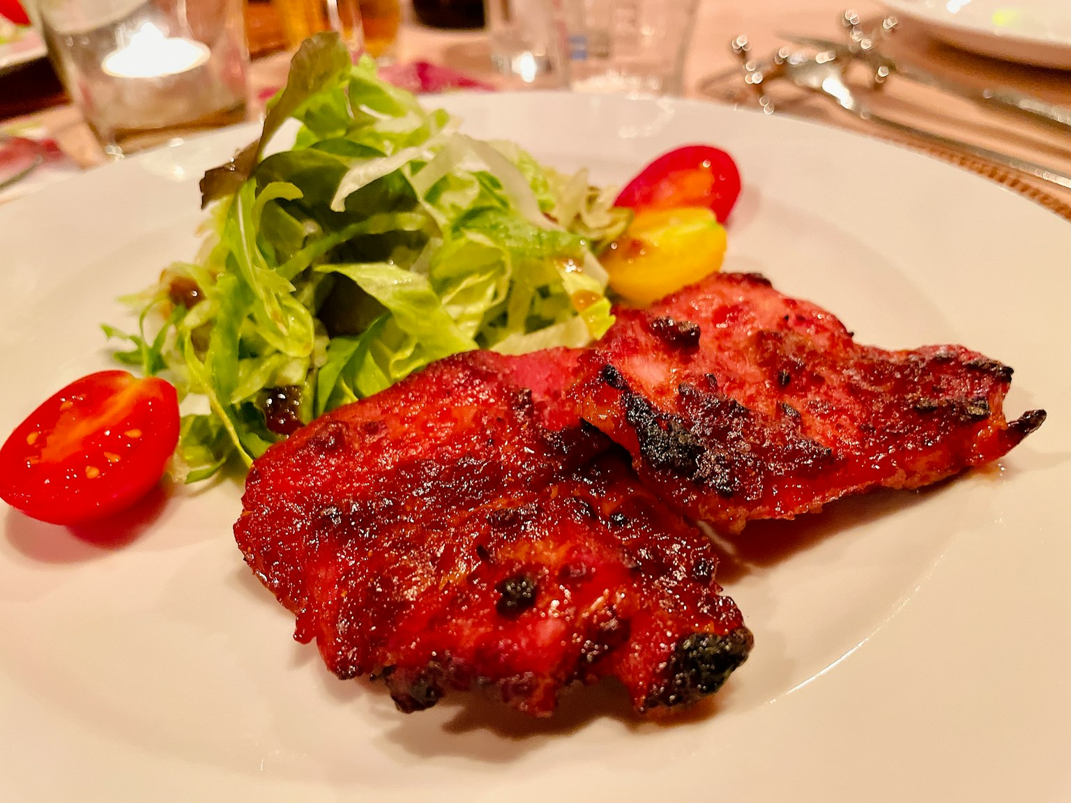 Cuisses de poulet grillées avec une salade fraîche et des tomates cerises