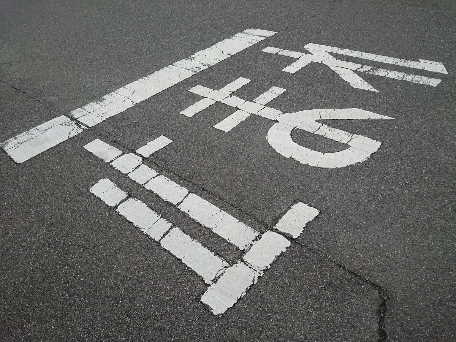 White road markings featuring numbers and symbols