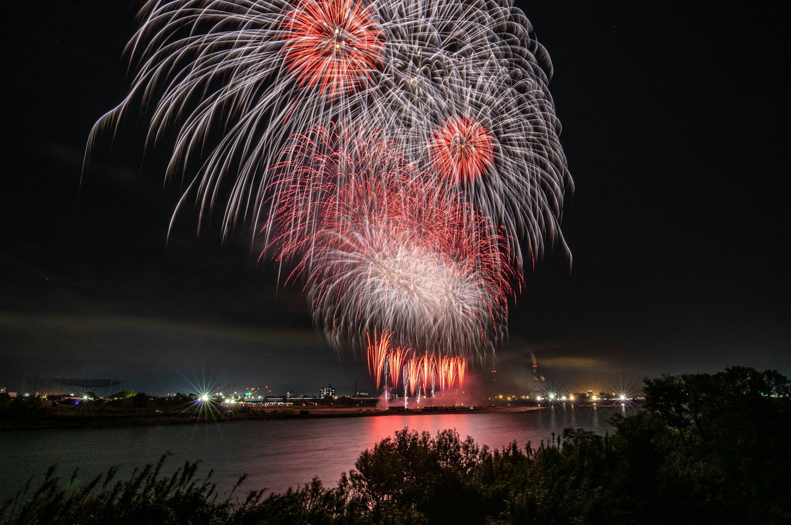 Spectacular fireworks display with red and white colors lighting up the night sky