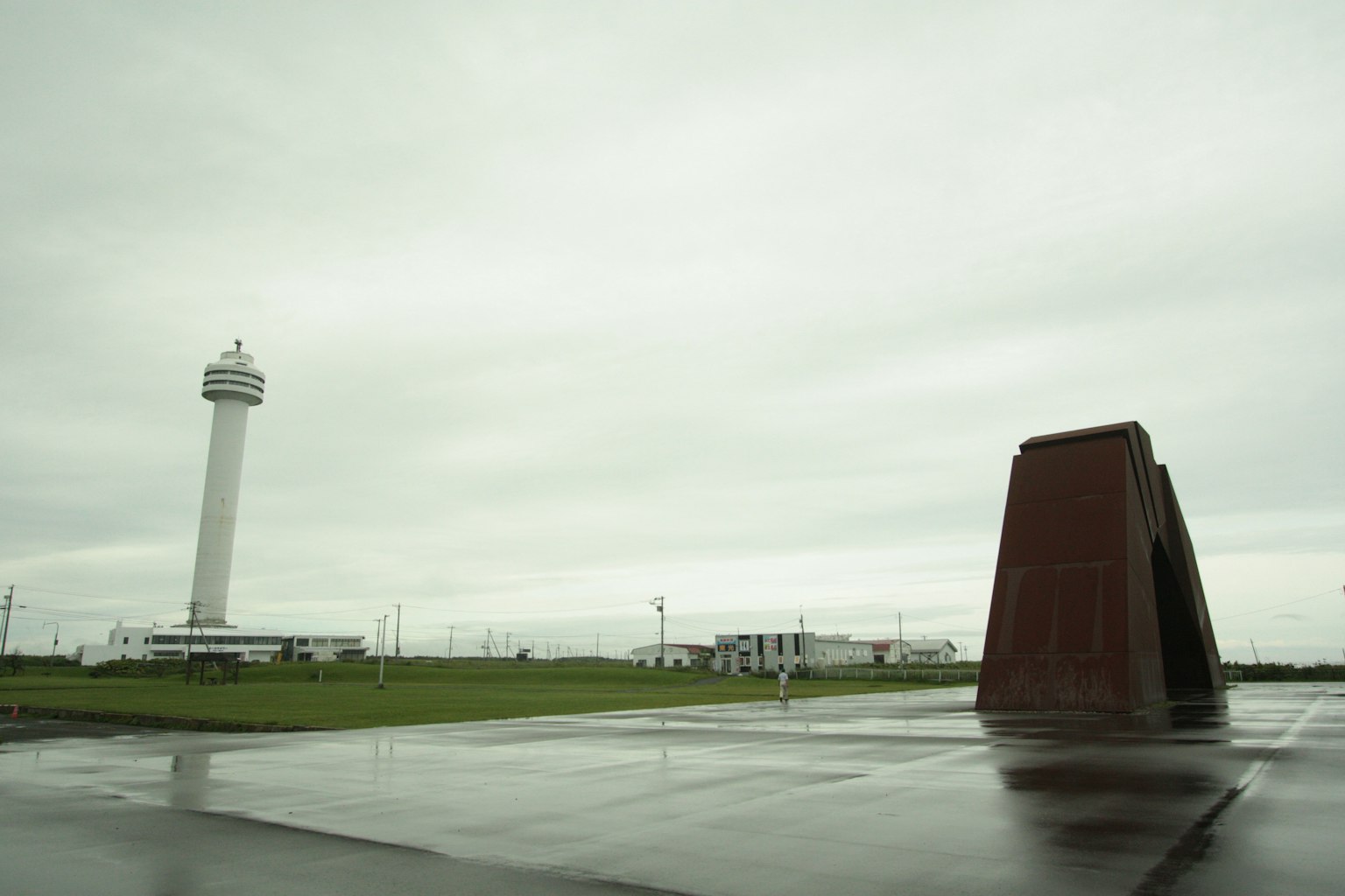 Ampio spazio aperto con una torre di controllo aeroportuale e un monumento rosso