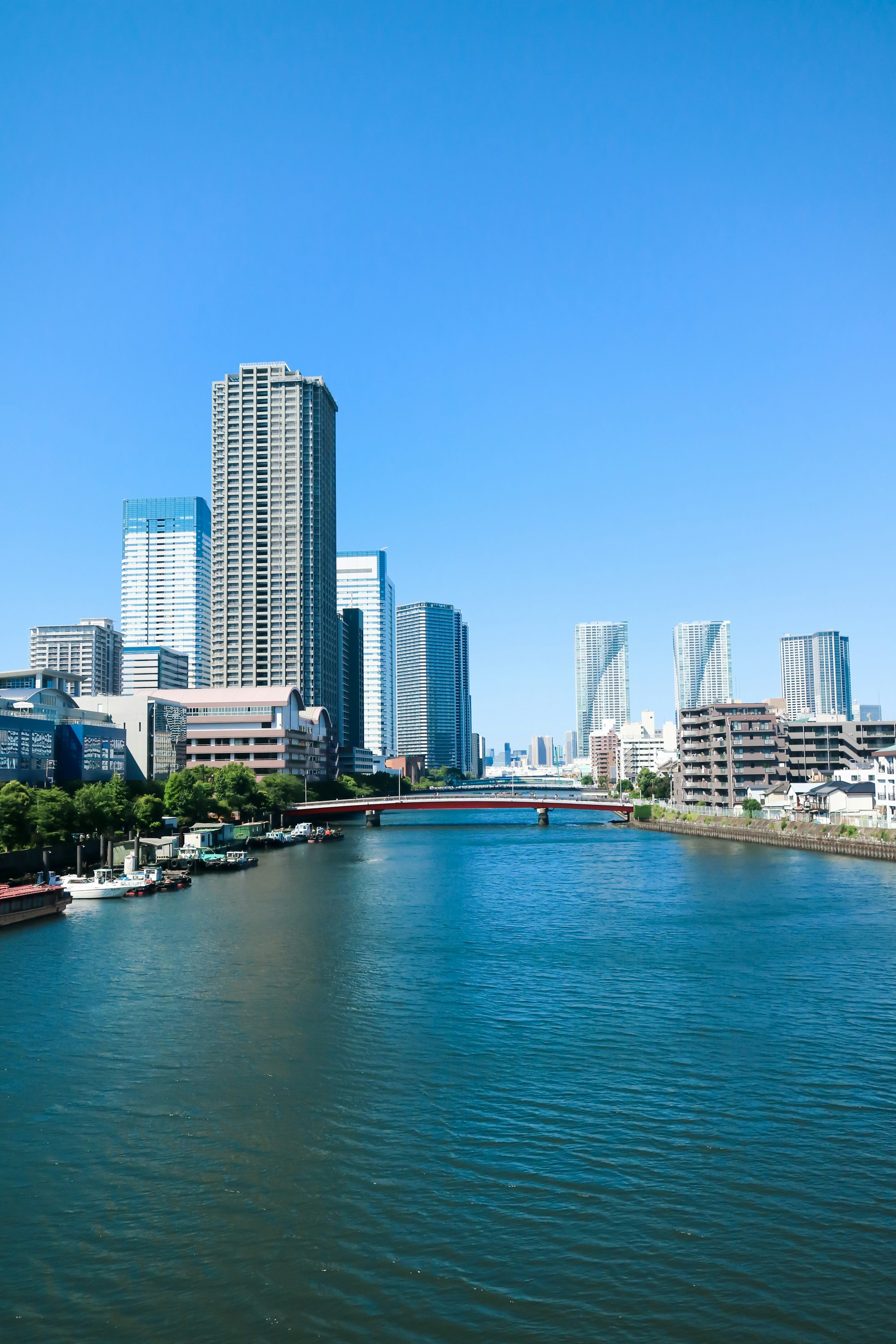 川沿いの都市の高層ビル群と青空