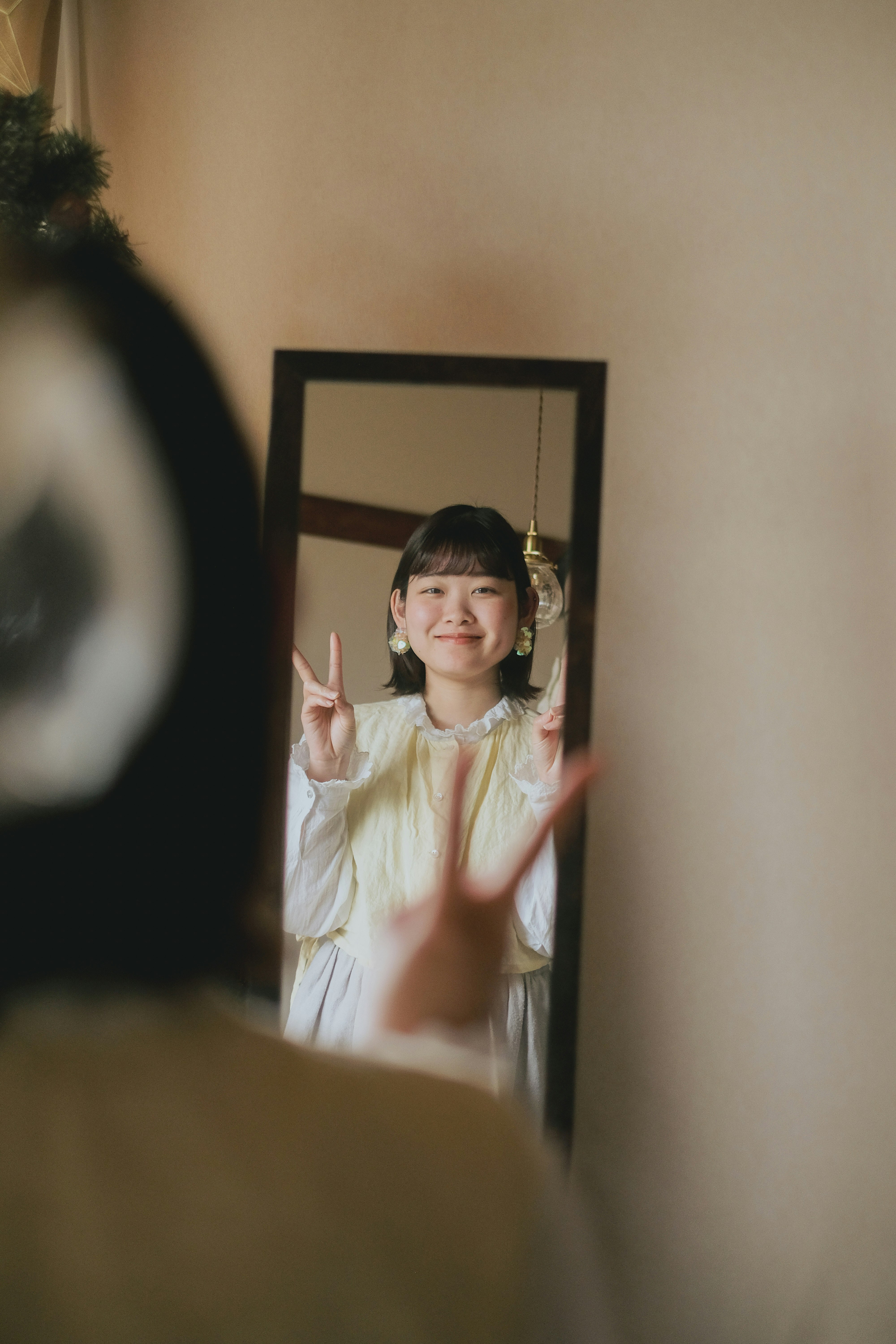鏡の前で手を振る子どもの笑顔