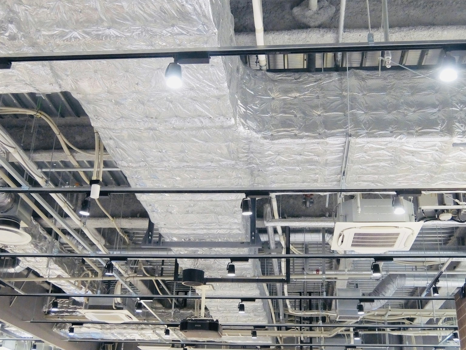 Soffitto industriale con tubi e apparecchi di illuminazione