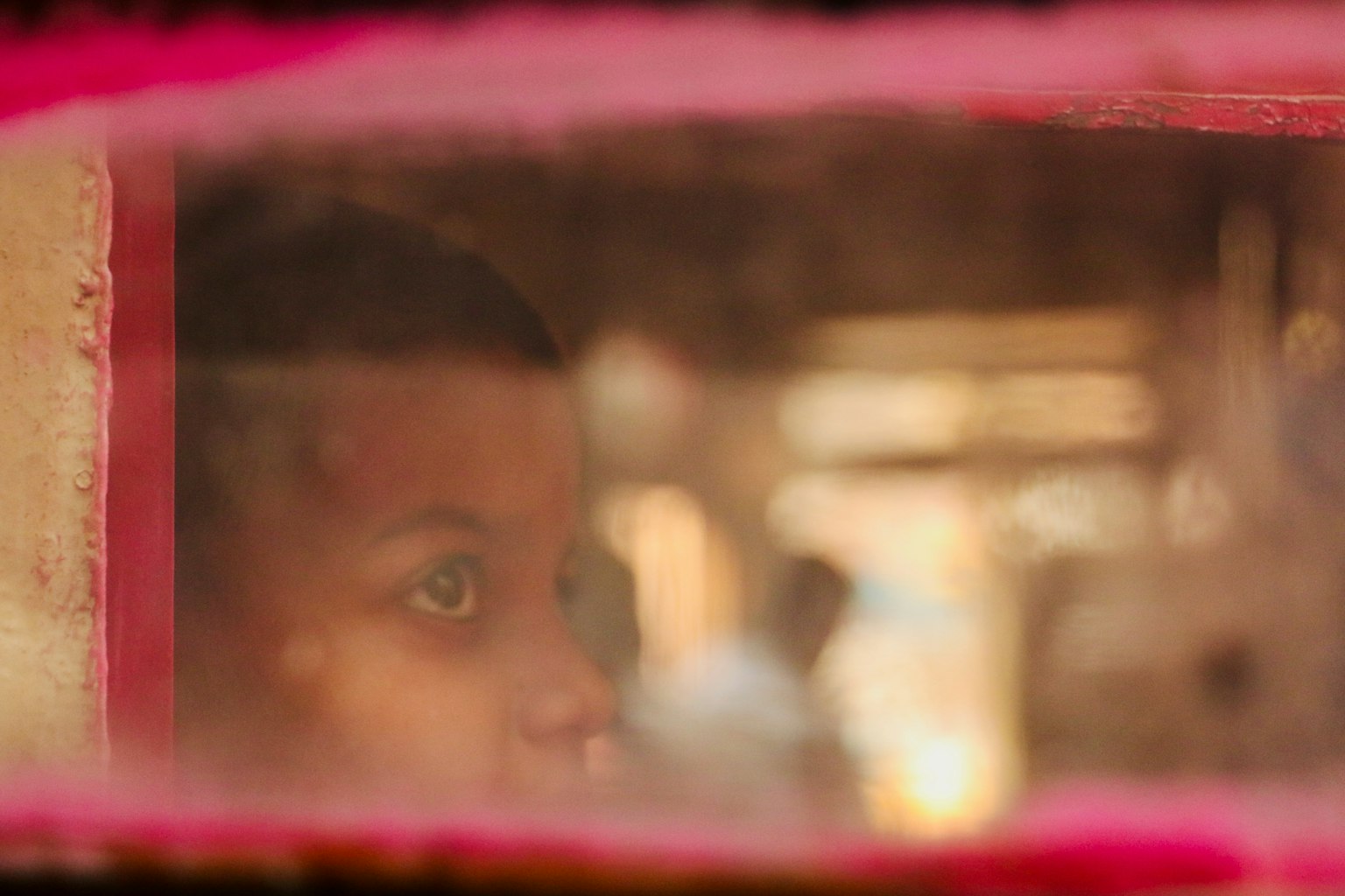 A child's captivating eyes gazing through a window