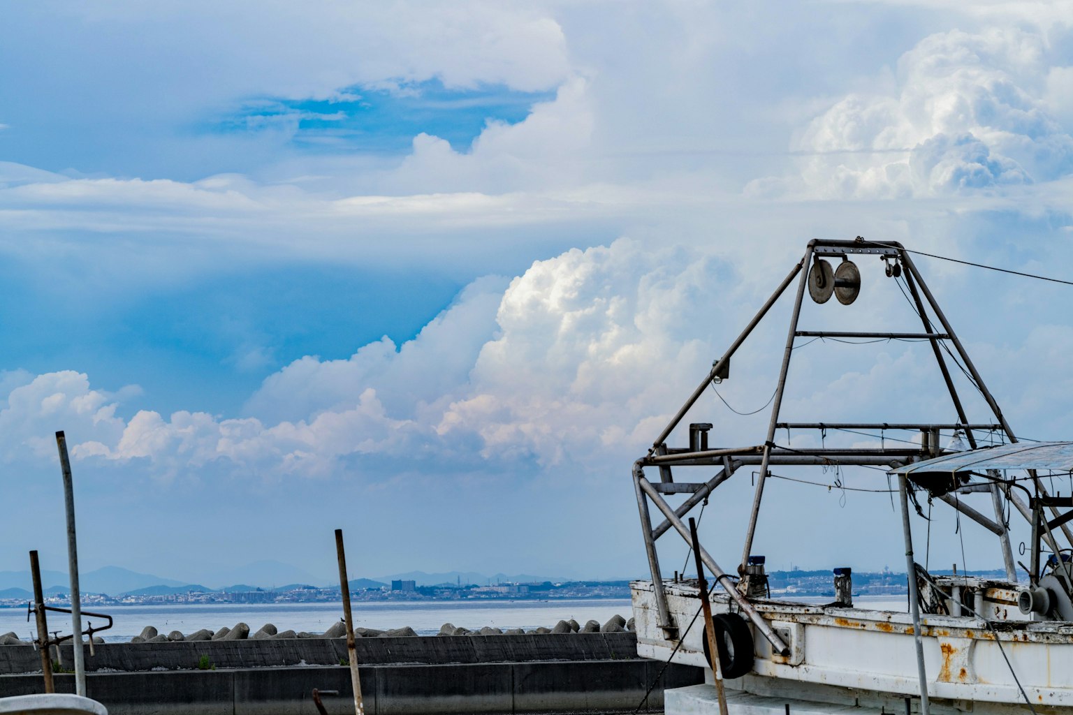 Part of an old fishing boat against a blue sky with clouds