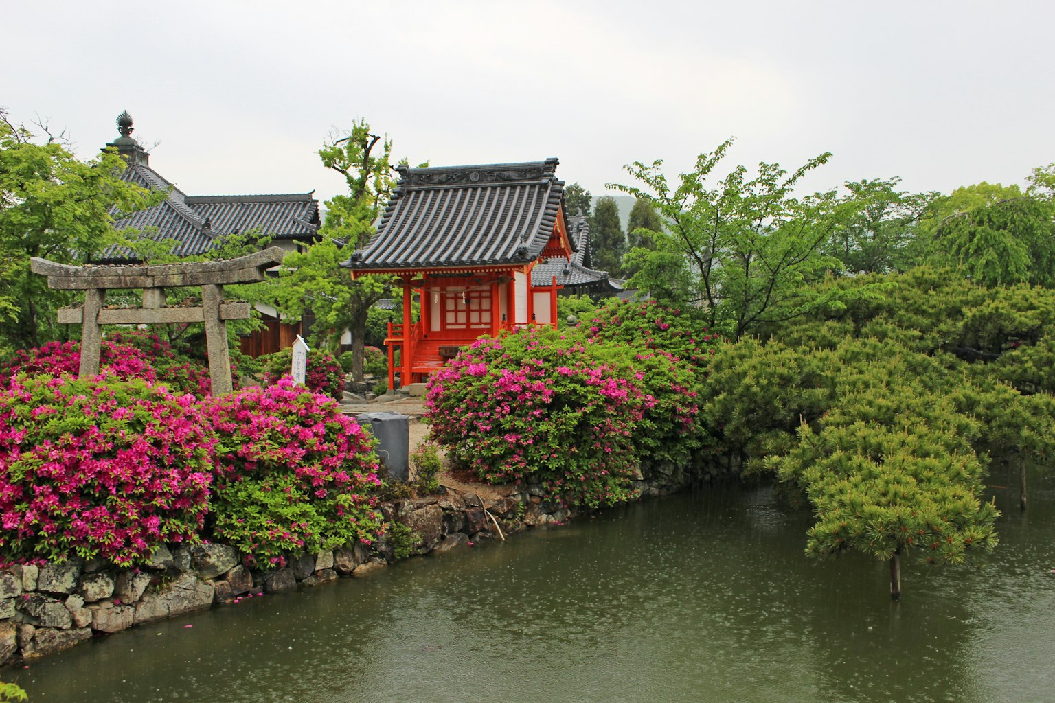 Un hermoso jardín japonés con un edificio rojo y flores vibrantes