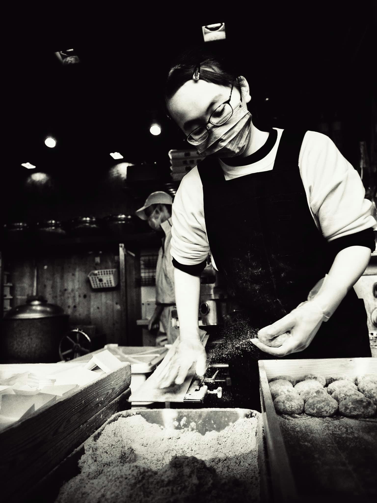 Una artesana femenina trabajando con ingredientes en un mercado en blanco y negro