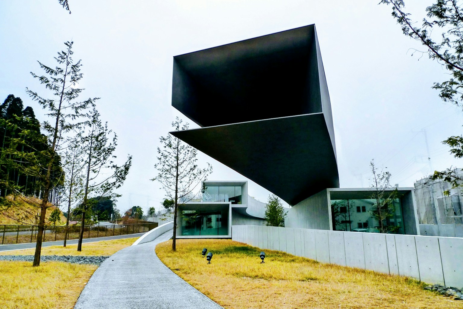 現代的な建築デザインの建物と周囲の緑地
