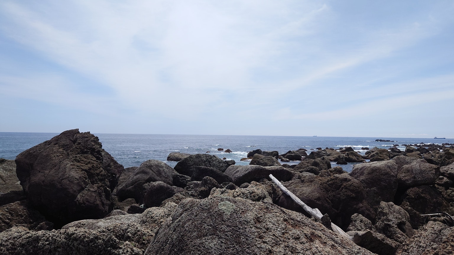 Batu pantai dengan pemandangan laut dan langit biru